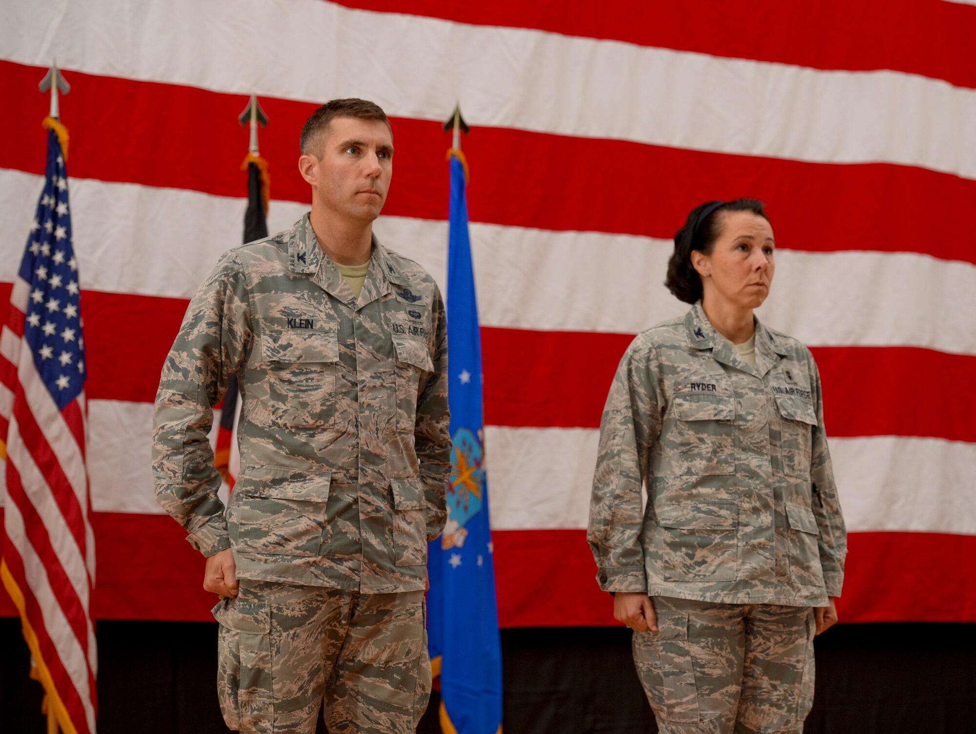 Col. John Klein, 386th Air Expeditionary Wing commander, and Col. Jeannine Ryder, 386th Expeditionary Medical Group commander, stand at attention during a Bronze Star citation reading. Ryder was awarded the medal just before relinquishing command of the 386th EMDG during a change of command ceremony June 8, 2014. (U.S. Air Force photo by Staff Sgt. Jeremy Bowcock)