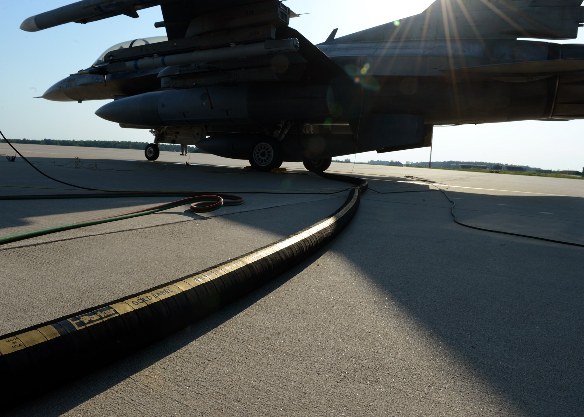 A U.S. Air Force F-16 Fighting Falcon fighter aircraft is refueled at a hot refueling pit after flying a training mission above the skies at Lask Air Base, Poland, June 9, 2014. 18 U.S. F-16 aircraft were a part of the U.S. Aviation Detachment Rotation 14-3 that supported Polish-led Exercise EAGLE TALON and U.S. Navy-led BALTOPS 14. These exercises maximize readiness for real-world operations with NATO allies and maintain a continuous presence in Eastern Europe. (U.S. Air Force photo by Airman 1st Class Kyle Gese/Released)