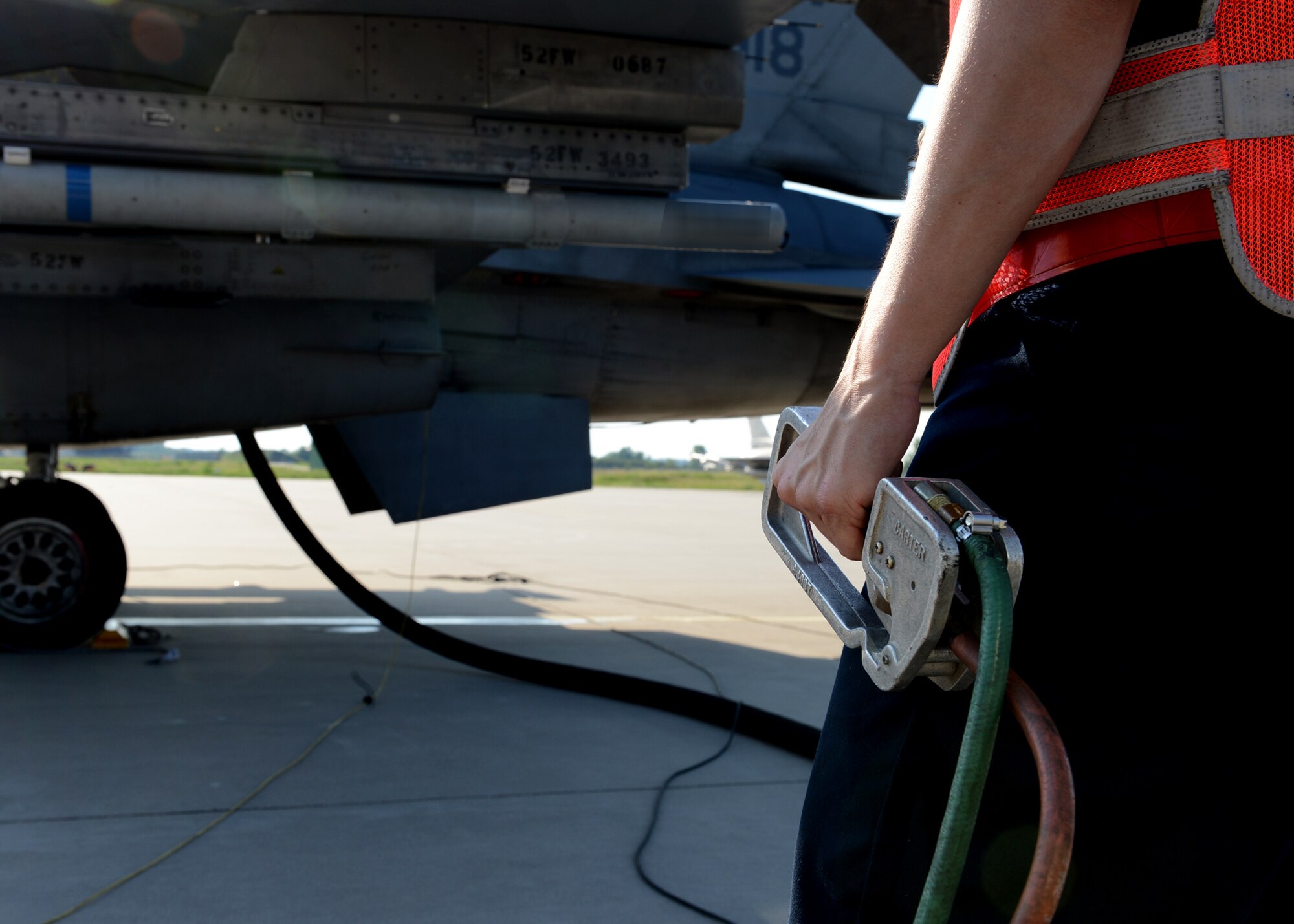 U.S. Air Force Senior Airman Katherine Meakins, 480th Fighter Squadron crew chief, Spangdahlem Air Base, Germany, pumps fuel into a returning U.S. Air Force F-16 Fighting Falcon fighter aircraft at Lask Air Base, Poland, June 9, 2014. There are four Polish Air Force Oshkosh R-11 fuel trucks at Lask Air Base that support refueling operations for U.S. and Polish aircraft participating in Exercise EAGLE TALON, BALTOPS 14 and U.S. Aviation Detachment Rotation 14-3 activities. The trucks pump approximately 600 gallons of fuel per minute. This is the first time hot pit refueling has been done in Poland by U.S. Forces. (U.S. Air Force photo by Airman 1st Class Kyle Gese/Released)