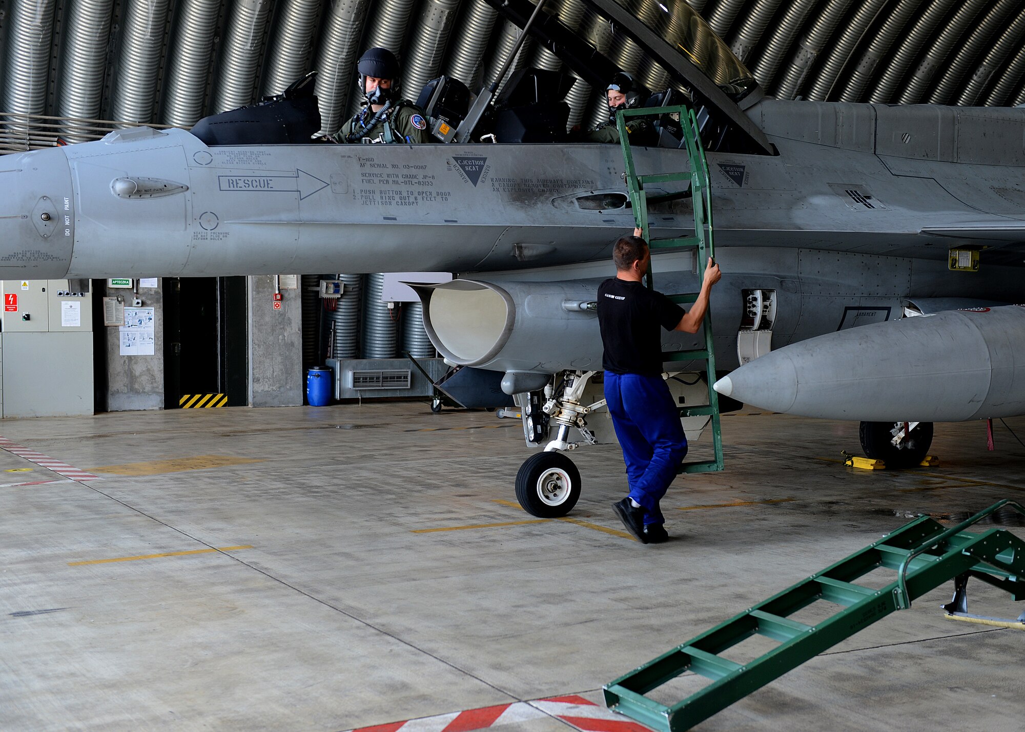 Polish air force Warrant Officer Cichecki Martin, crew chief, removes a ladder from an F-16 Fighting Falcon fighter aircraft in preparation for Exercise EAGLE TALON at Lask Air Base, Poland, June 10, 2014. NATO allies were either on a blue and red team to simulate friendly and enemy aircraft. During combined exercises such as these, pilots train in a simulated environment to enhance air-to-air and air-to-surface capabilities. (U.S. Air Force photo by Airman 1st Class Kyle Gese/Released)