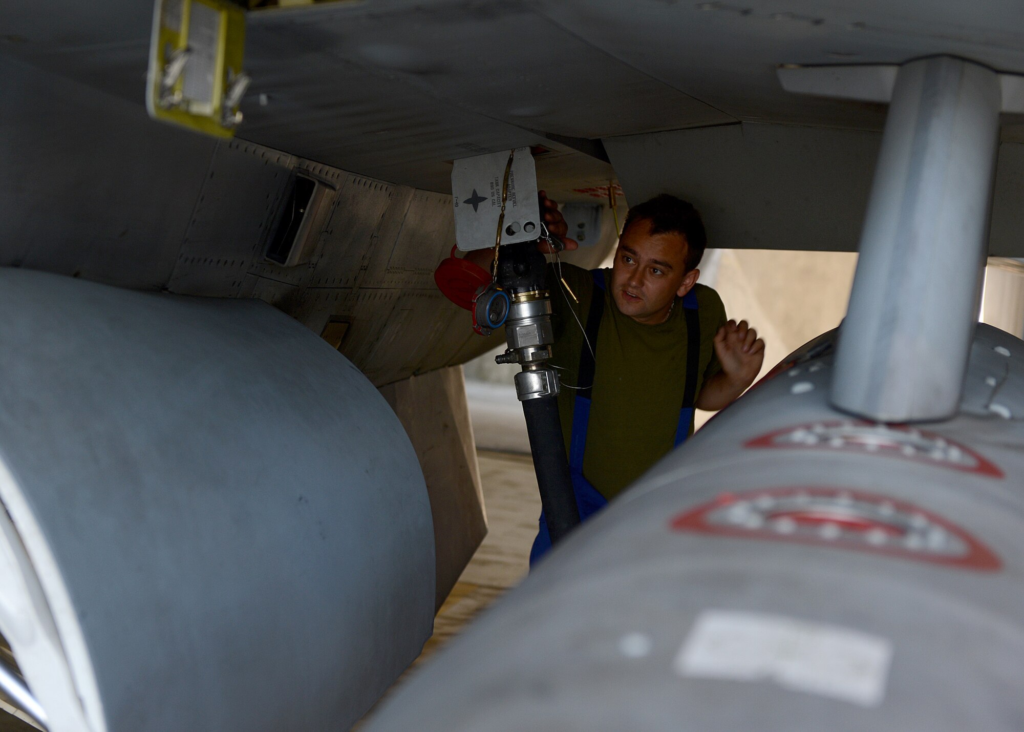 Polish air force Corporal Paliwoda Ukosz, fuels technician, refuels an aircraft before its departure, June 10, 2014, to join NATO allies in the sky above Lask Air Base, Poland. The U.S. and Polish continue to work together to refuel aircraft during Exercise EAGLE TALON, a Polish-led combined exercise. There are two shifts for refueling: day shift and night shift. The Polish Air Force refuels aircraft during the daily flying operations, while the U.S. Air Force executes hot pit refueling, which shortens the flying window and increases capability to fix aircraft in a timely manner. (U.S. Air Force photo by Airman 1st Class Kyle Gese/Released)