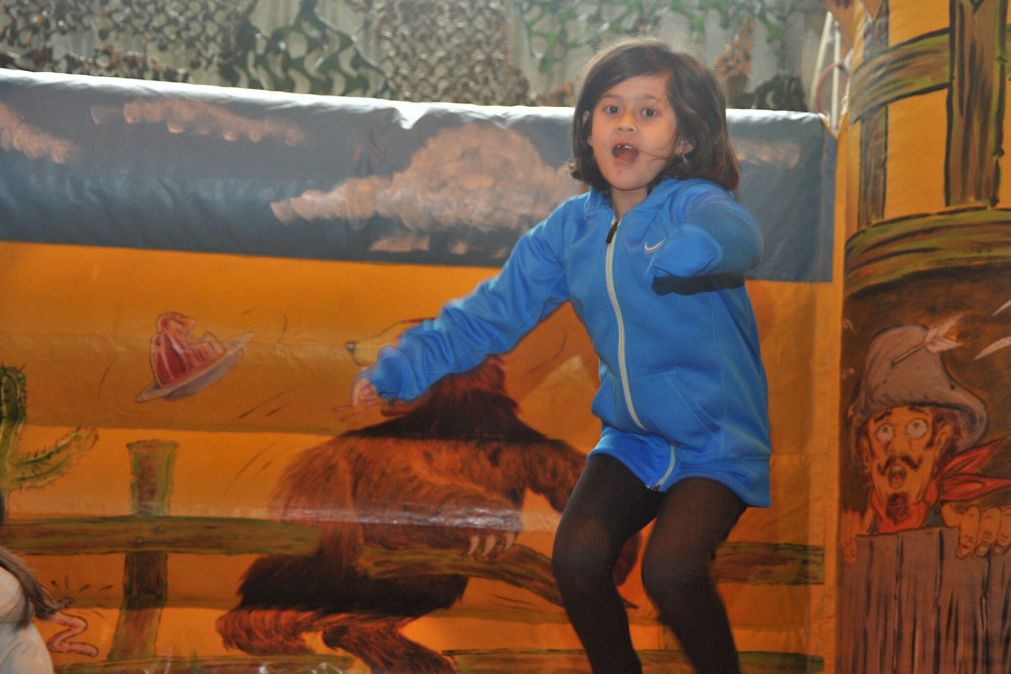 Seven-year-old Scarlett Lawlor, daughter of U.S. Navy Lt. Justin Lawlor, U.S. Africa Command, hops around inside a bouncy castle during Resiliency Day in hangar 92 at RAF Molesworth, United Kingdom May 30, 2014. Service members, Department of Defense contractors, civilians and dependents of RAFs Alconbury and Molesworth attended a two-day event filled with free food, motivational speaking and children-friendly games, hosted by the 423rd Chaplain’s office and U.S. Africa Command personnel. (U.S. Air Force photo by Staff Sgt. Ashley Hawkins/Released)