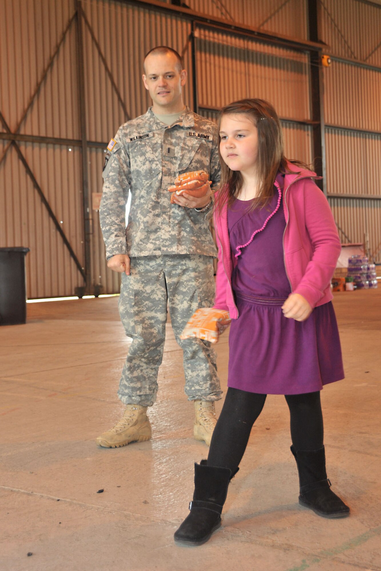 U.S. Army Chief Warrant Officer 3 Dick Wilkinson, U.S. Africa Command staff officer, watches as his daughter, 7-year-old Genevieve, throw bean bags in a game of corn hole during Resiliency Day in hangar 92 at RAF Molesworth, United Kingdom May 30, 2014. The 423rd Chaplain’s Office expanded their Resiliency Day with U.S. Africa Command’s annual spring fling to provide stress-free and motivational family-fun for RAF Alconbury and RAF Molesworth personnel and their families. (U.S. Air Force photo by Staff Sgt. Ashley Hawkins/Released)