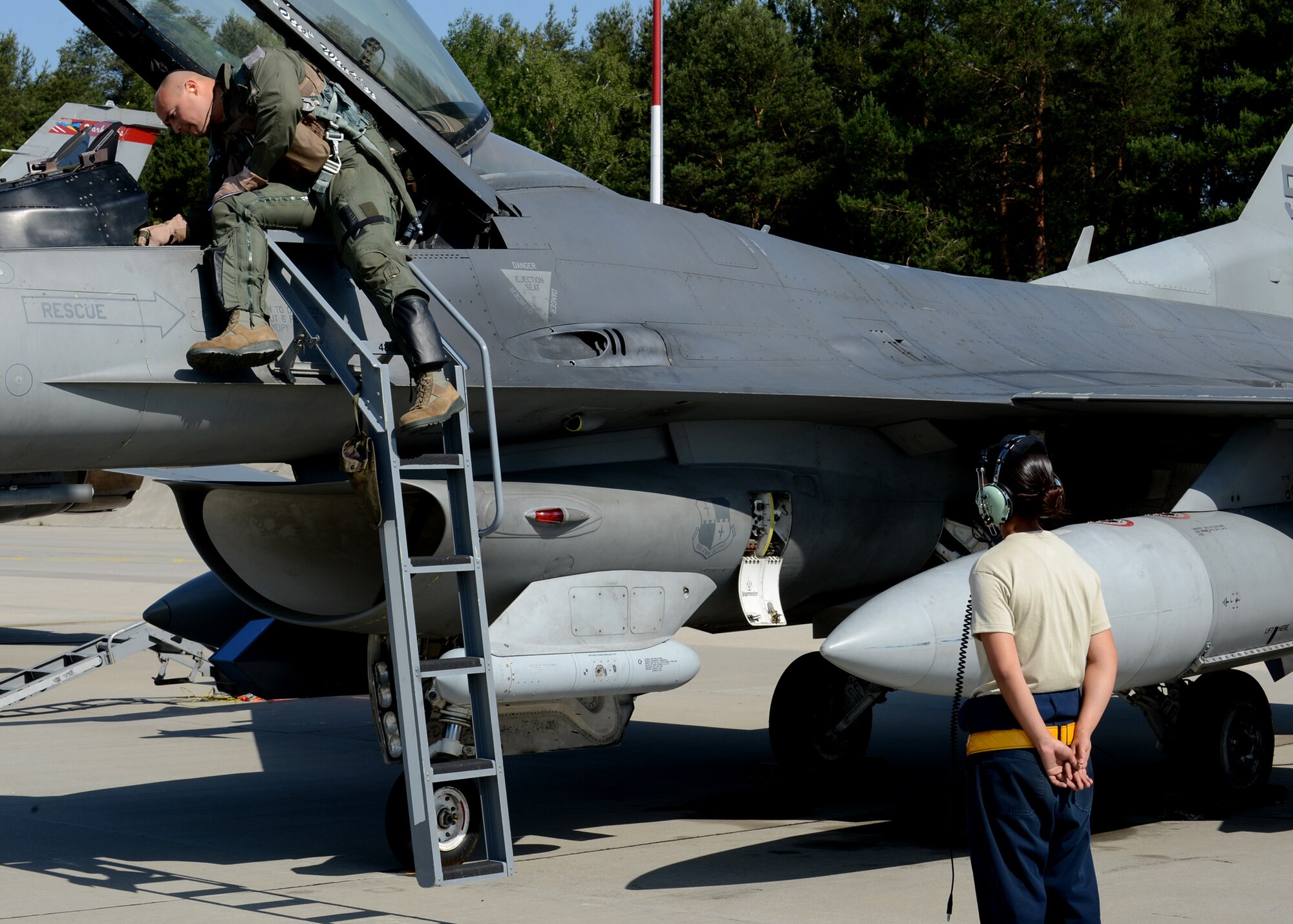 U.S. Air Force Maj. Nathanael Karrs, a 480th Fighter Squadron F-16 Fighting Falcon fighter aircraft pilot from Rocky Mount, N.C., and Senior Airman Kimberly Szydlowski, a 52nd Aircraft Maintenance Squadron F-16 Fighting Falcon aircraft crew chief from St. Louis, prepare for take-off at Lask Air Base, Poland, June 9, 2014. Karrs participated in exercise EAGLE TALON, which aimed to increase interoperability with Polish armed forces, strengthen partnerships with NATO allies and increase readiness for real-world operations. (U.S. Air Force photo by Airman 1st Class Kyle Gese/Released)