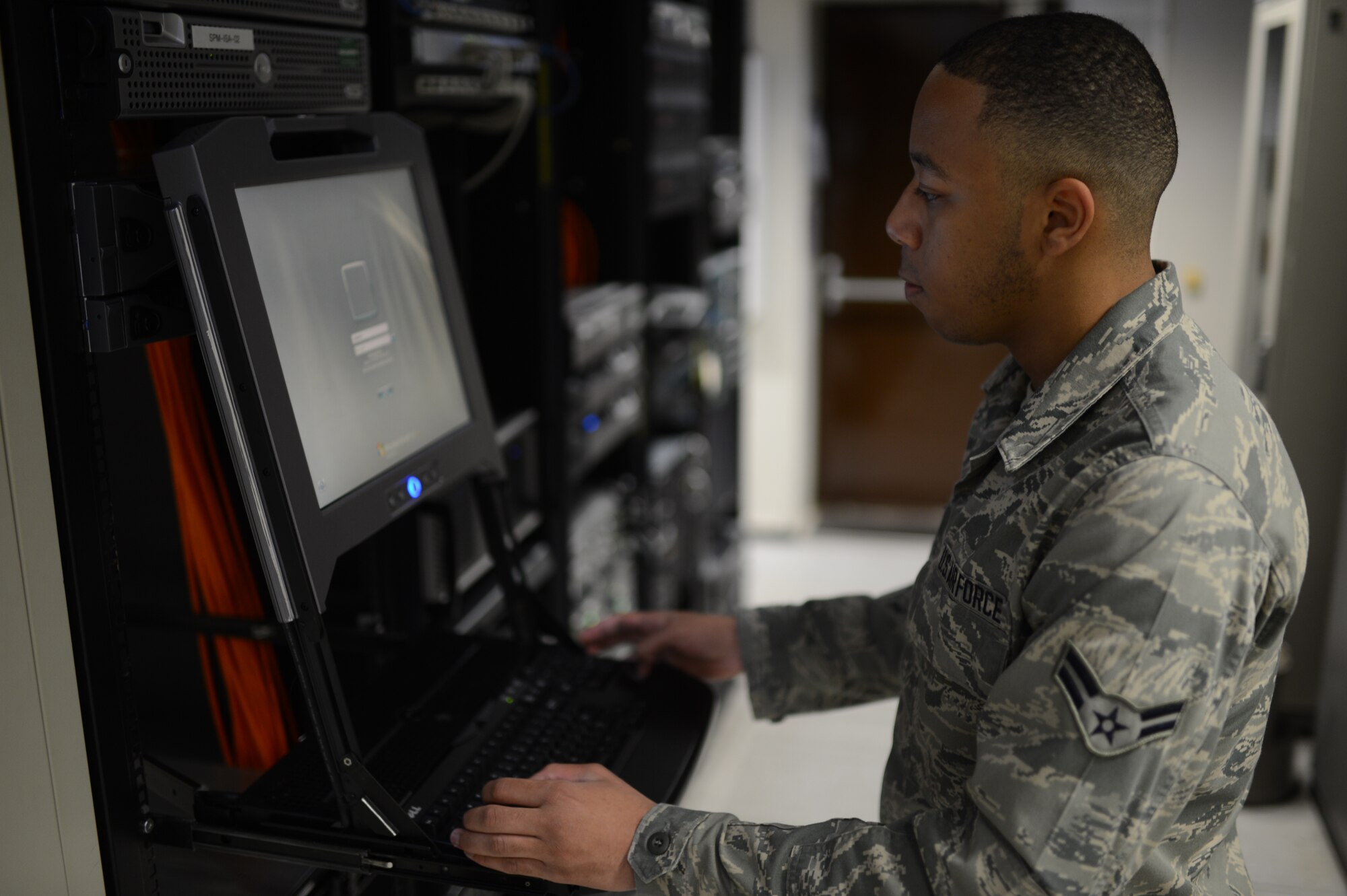 U.S. Air Force Airman 1st Class Kadel Loyd, 52nd Communications Squadron cyber system operations technician from Las Vegas, logs in to a computer access terminal inside a server room at Spangdahlem Air Base, Germany, June 10, 2014. Through this computer terminal, Airmen can remote in to system servers, push network patches, troubleshoot errors and update the base’s computer network. (U.S. Air Force photo by Senior Airman Gustavo Castillo/Released)