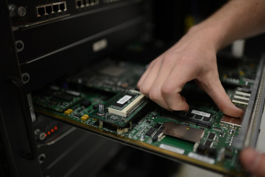 U.S. Air Force Airman 1st Class Zachery Cook, 52nd Communications Squadron cyber system operations technician from Cleveland, inspects a server from a computer training lab at Spangdahlem Air Base, Germany, June 10, 2014. Airmen must check computer parts for any dust or damage that would otherwise cause a preventable system malfunction. (U.S. Air Force photo by Senior Airman Gustavo Castillo/Released)