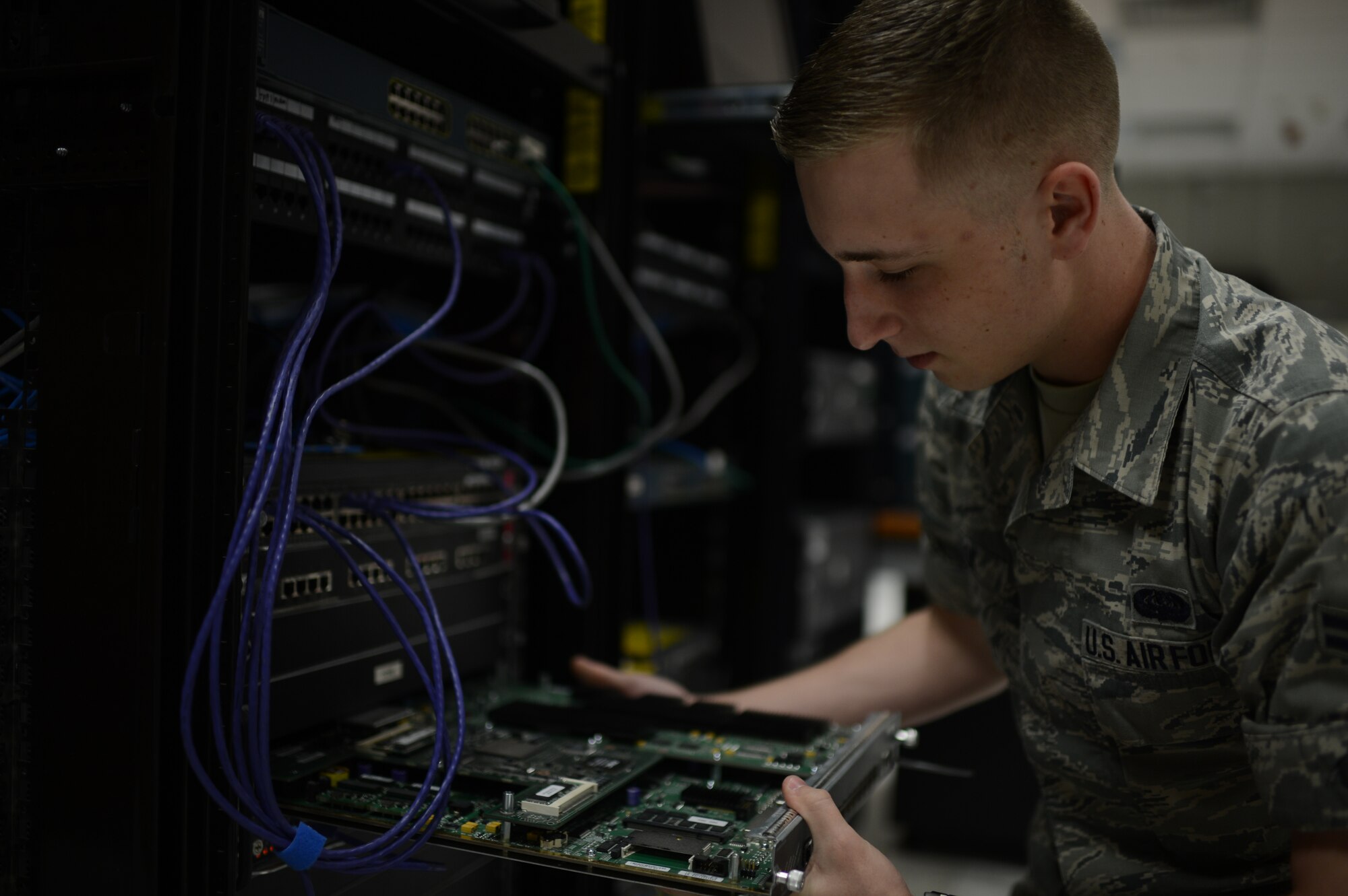 U.S. Air Force Airman 1st Class Zachery Cook, 52nd Communications Squadron cyber system operations technician from Cleveland, removes a computer component from a training lab at Spangdahlem Air Base, Germany, June 10, 2014. Airmen use the training lab to conduct training and tests on a stand-alone network, so any training errors will not affect Spangdahlem’s live network. (U.S. Air Force photo by Senior Airman Gustavo Castillo/Released)