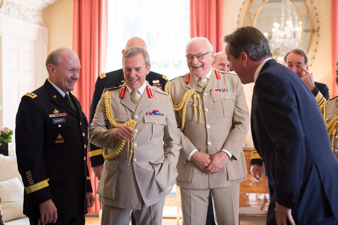 U.S. Army Gen. Martin E. Dempsey, left, chairman of the Joint Chiefs of Staff, British Gen. Nicholas Houghton, second from left, chief of Britain's defense staff, British Gen. Peter Wall, second from right, Britain's army chief of staff, and British Prime Minister David Cameron, right, share a moment during a meeting with U.S. and British counterparts in London, June 10, 2014.