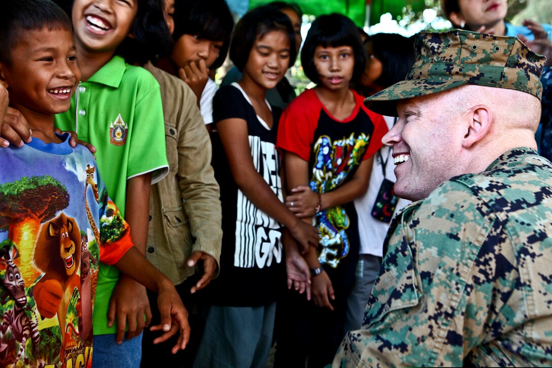 U.S. Marine Corps Maj. Jason Wintermute, right, laughs with children in Lop Buri, Thailand, Nov. 20, 2011. Wintermute is an anti-terrorism force protection officer assigned to the III Marine Expeditionary Force flood relief command element.  
