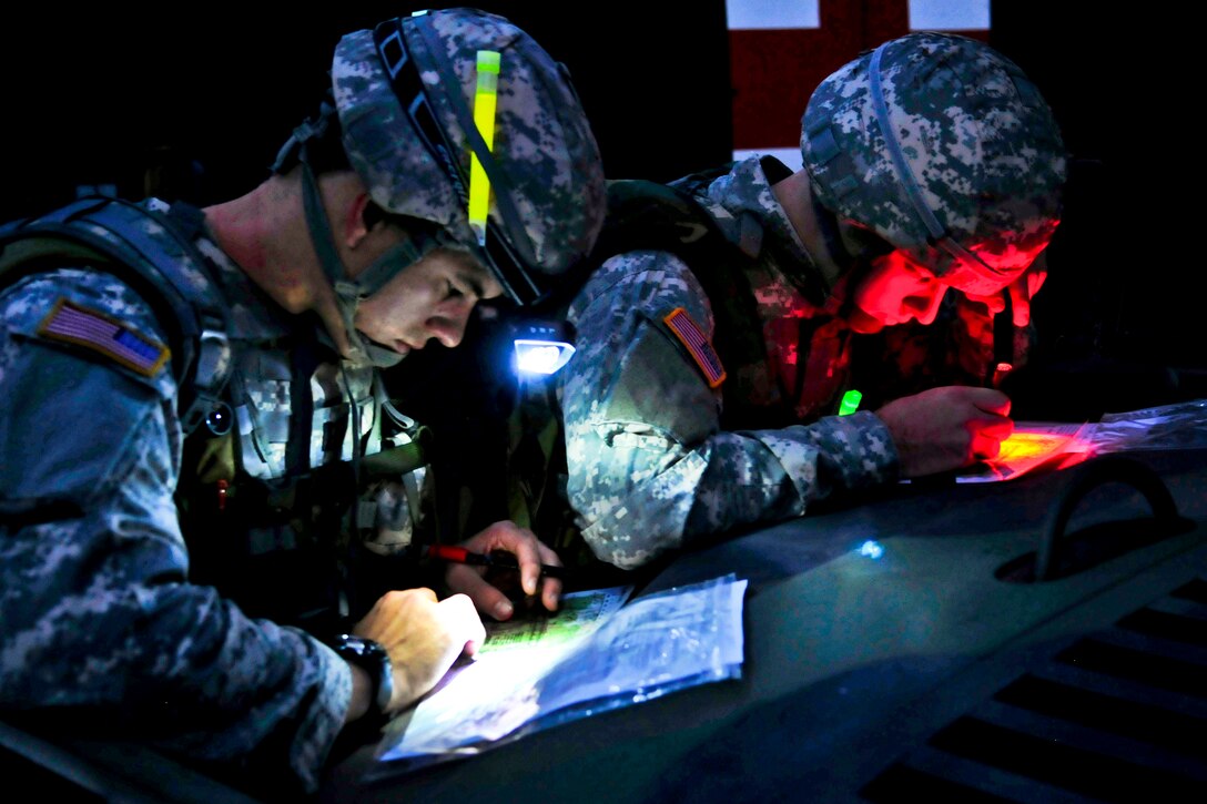 U.S. Army Cpt. Nick Franck, left, and 2nd Lt. Charles Smith, right, plot their points on maps for the day-to-night land navigation course during the U.S. Army Europe Best Junior Officer Competition on U.S. Army Garrison Grafenwoehr in Germany, Nov. 16, 2011. Franck is assigned to the 12th Combat Aviation Brigade, and Smith is assigned to the 18th Engineer Brigade.  
