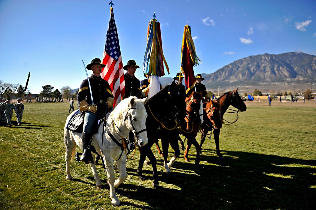 Soldiers from the 4th Infantry Division mounted color guard participate in the pass-in-review portion of the division's change of command ceremony on Fort Carson, Colo., Nov. 16, 2011.  
