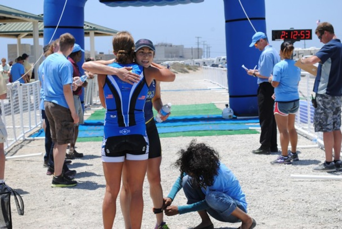 Air Force 2nd Lt. Samantha Morrison, who finished first among the women, congratulates the second-place winner as she crosses the finish line, Navy Lt. Rachel Beckman. 