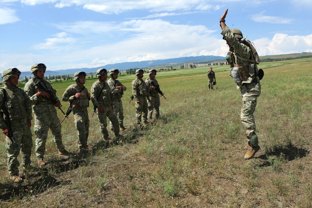 A range-safety officer from the Georgian Armed Forces demonstrates a burpee to Georgian soldiers before a “stress shoot,” a combat-marksmanship range that tests accuracy after a high-intensity metabolic workout circuit as part of the fourth iteration of exercise Agile Spirit. Agile Spirit 14 is an annually-scheduled multilateral engagement hosted by the Caucasus country that began in 2011 to deepen the strategic partnership between the two countries by conducting brigade and battalion-level training engagements, to include small-unit interaction between the Marines and Georgians that demonstrates their commitments toward collective, global security.