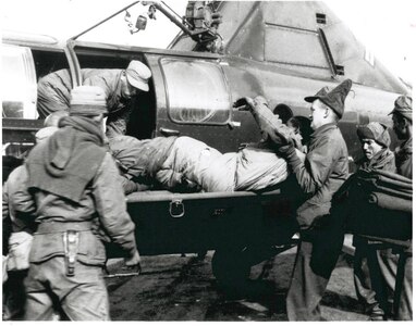 Wounded Puerto Rican Soldier of the 65th Infantry Regiment is removed from helicopter at an aid station. Helicopter evacuation of the wounded was pioneered during the Korean War.