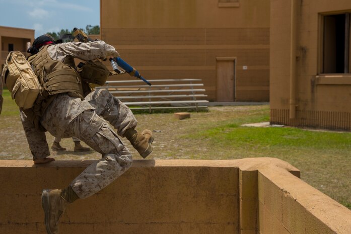 A Marine with Alpha Company, 8th Engineer Support Battalion, 2nd Marine Logistics Group leaps over a wall during a Military Operations in Urban Terrain exercise aboard Camp Lejeune, N.C., June 5, 2014. Marines with the company trained to maneuver in urban environments while conducting combat and engineering operations for three days prior to a final exercise designed to test their combined knowledge of MOUT behavior and tactics. 