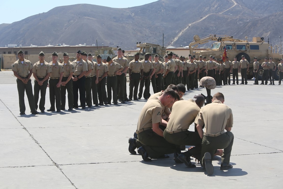 Marines with 1st Combat Engineer Battalion, 1st Marine Division, line up to approach a battle cross in memory of Lance Cpl. Matthew Rodriguez after a memorial service aboard Camp Pendleton, Calif., June 11, 2014. Rodriguez was killed in action on Dec. 11, 2013, while deployed in support of Operation Enduring Freedom, when an improvised explosive device struck his vehicle.