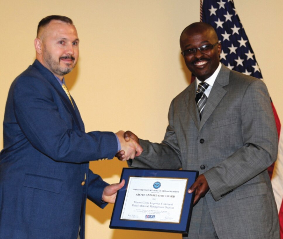 Andrew Trout, section supervisor, Retail Inventory Support Section, Logistics Services Management Center, Marine Corps Logistics Command, (left), receives Above and Beyond Award from Michael Bryant, field representative to U.S. Congressman Sanford D. Bishop Jr., 2nd Congressional District, Georgia, and state representative from the Employer Support of the Guard and Reserve, during a ceremony held at LOGCOM Headquarters, May 28.