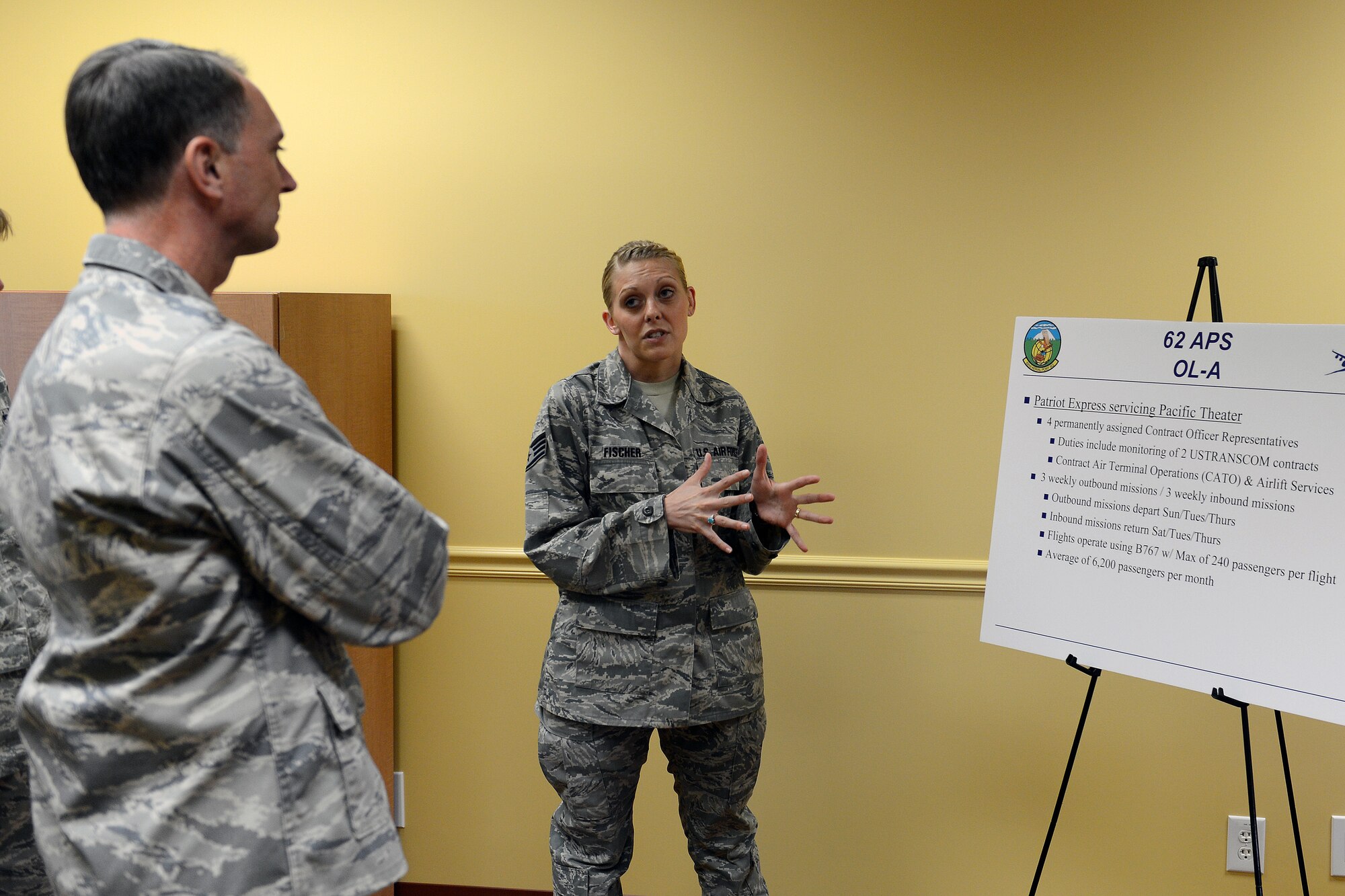 Staff Sgt. Amanda Fischer, 62nd Aerial Port Squadron contract officer representative, briefs Brig. Gen. Warren Berry, Headquarters Air Mobility Command director of logistics, on the 62nd APS Seattle-Tacoma International Airport Space-A terminal’s services June 12, 2014, at Joint Base Lewis-McChord, Wash. Berry visited McChord Field to meet with base leadership and gain a better understanding of Team McChord missions. (U.S. Air Force photo/Airman 1st Class Jacob Jimenez)