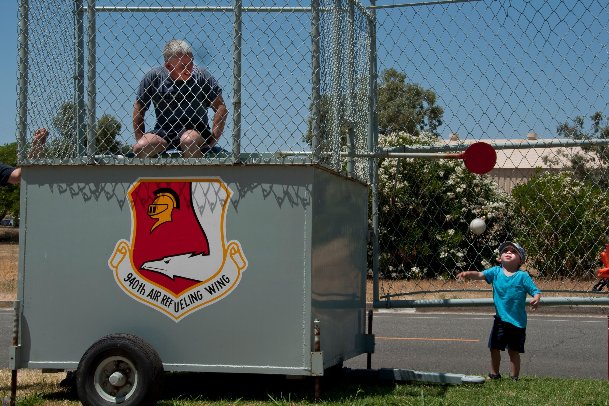 Liam Nickravesh-Burton, 3, son of Maj. Sheva Nickravesh, throws a ball towards the dunk tank where Col. John Trnka, 940th Wing commander, awaits during the wing Family Day picnic at Beale Air Force Base, Calif., June 8, 2014. The picnic is an annual event that welcomes friends and family members for an afternoon of food, games and entertainment. (U.S. Air Force photo by Staff Sgt. Brenda Davis/Released)