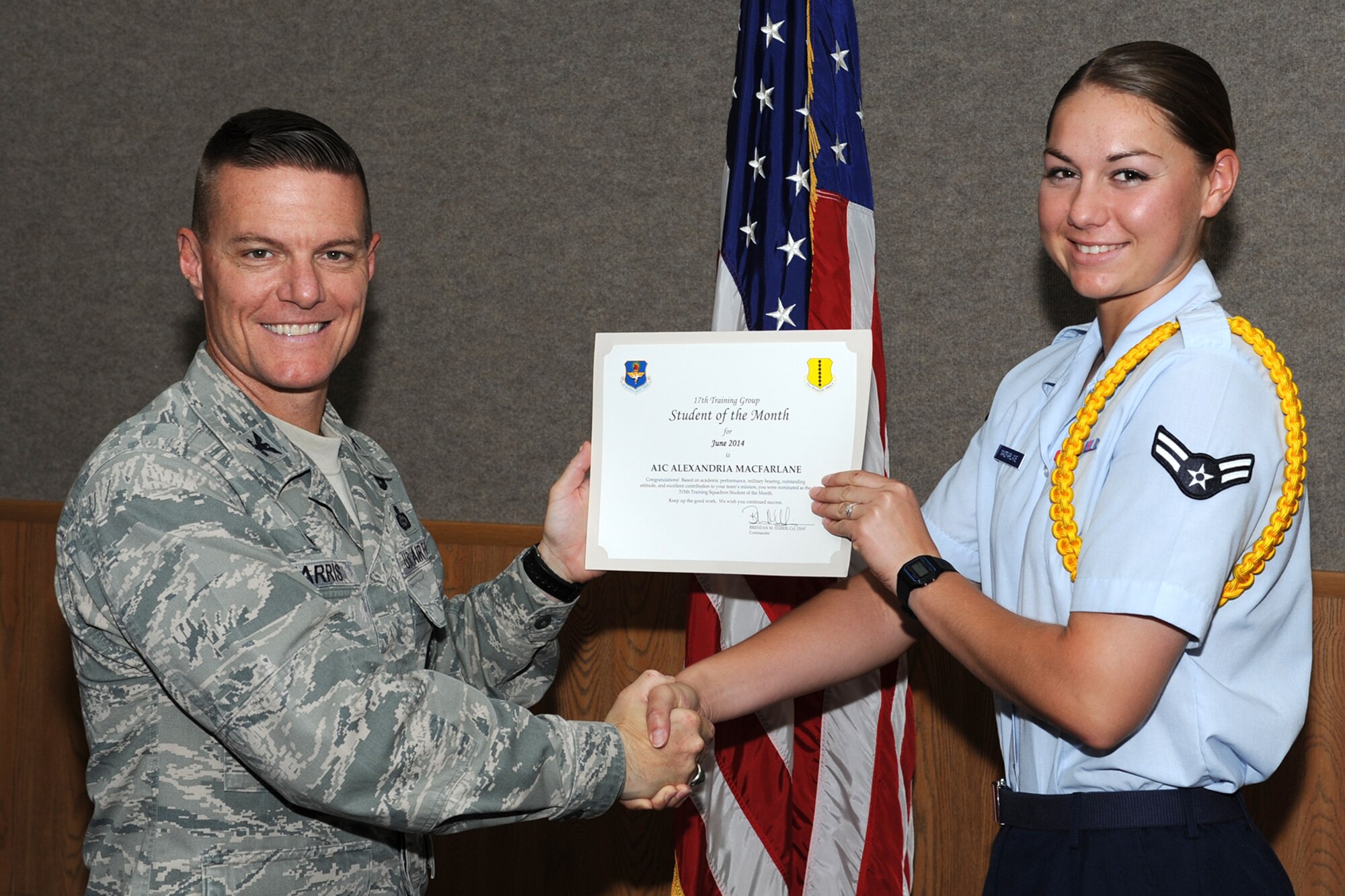 GOODFELLOW AIR FORCE BASE, Texas -- Col. Brendan M. Harris, 17th Training Group Commander, presents the 315th Training Squadron Enlisted Student of the Month award for May 2014 to Airman 1st Class Alexandria Macfarlane June 6. (U.S. Air Force photo/ Senior Airman Michael Smith)