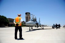 Clive Trammell, 47th Maintenance Directorate contract manager, stands by to marshal an AT-38B Talon on Laughlin Air Force Base, Texas, June 10, 2014. The basic function of aircraft marshalling is to control movement of aircraft and is accomplished using approved marshalling hand signals exercising due care and ensuring that the movement area is clear of obstacles, foreign object damage, vehicular and pedestrian traffic. (U.S. Air Force photo by Staff Sgt. Steven R. Doty, 47th Flying Training Wing.)(Released)