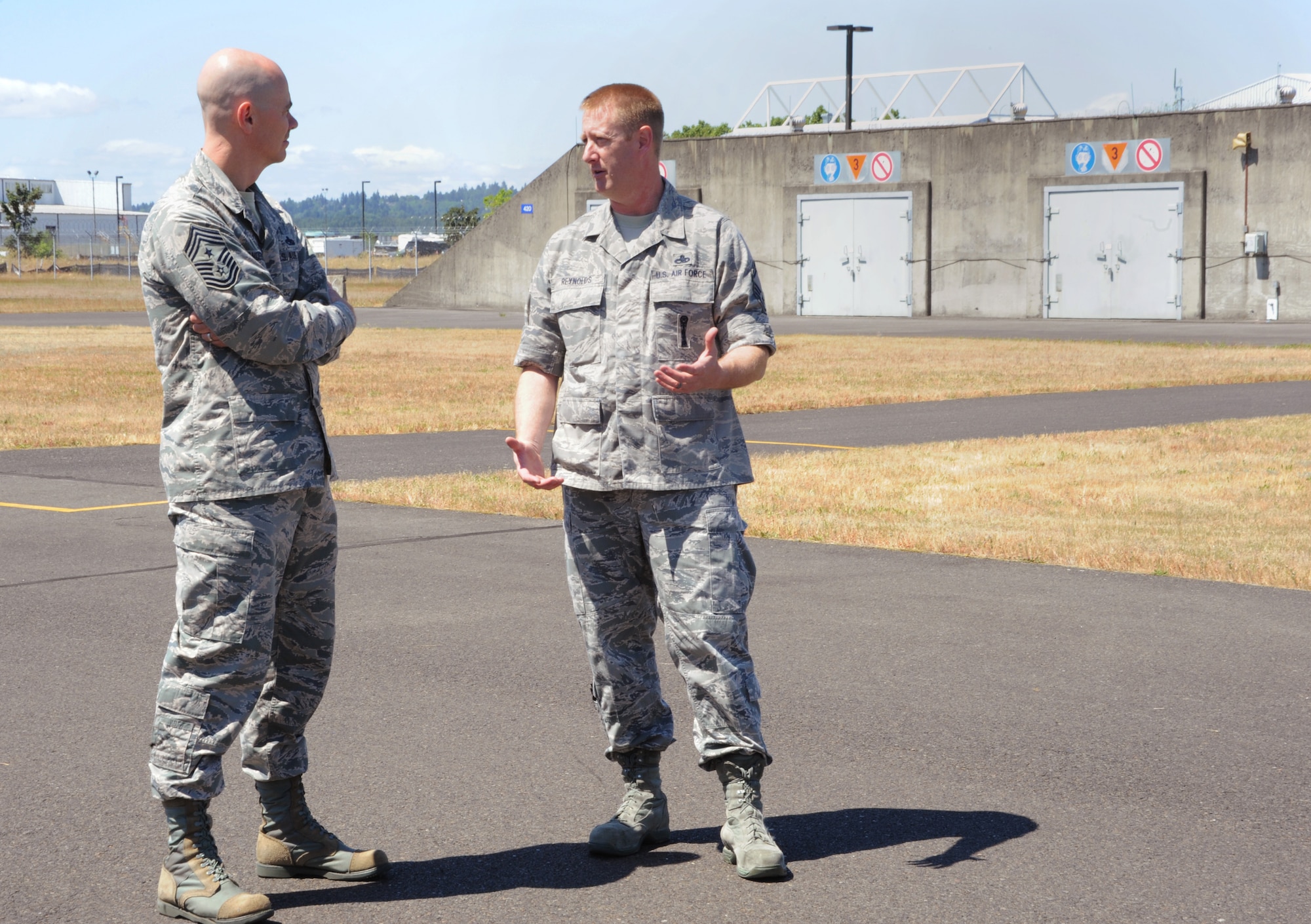 Senior Master Sgt. Jeffrey Reynolds, assigned to the 142nd Fighter Wing Maintenance Group, right, takes Ronald C. Anderson Jr., Command Chief Master Sgt., 1st Air Force, left, on a tour of the munitions area at the Portland Air National Guard Base, Ore., June 10, 2014. (Air National Guard photo by Tech. Sgt. John Hughel, 142nd Fighter Wing Public Affairs/Released)