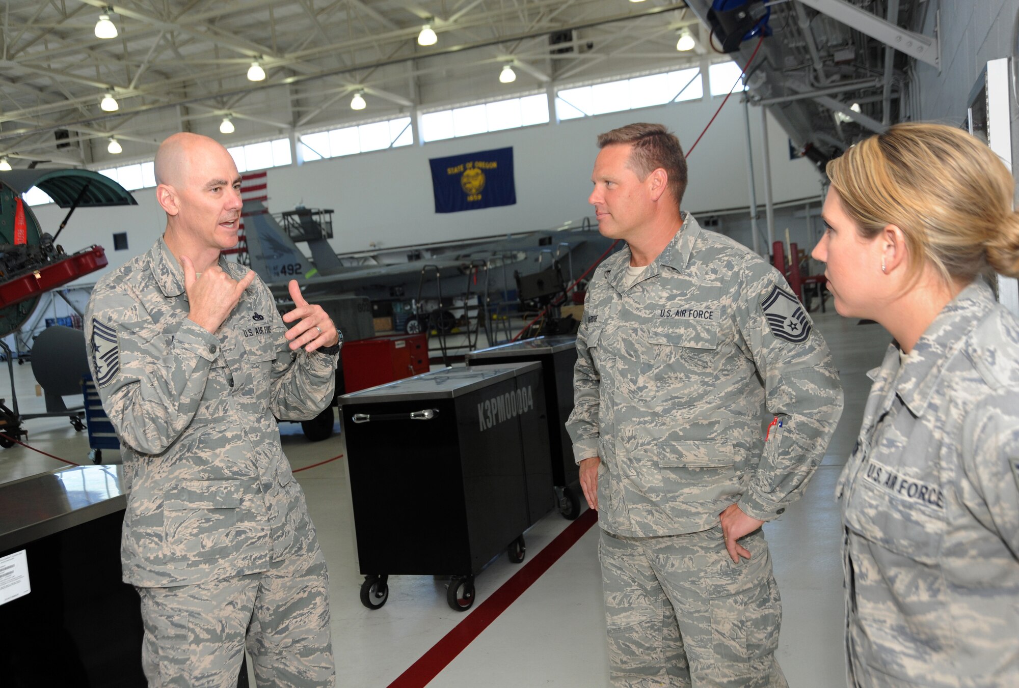 Ronald C. Anderson Jr., Command Chief Master Sgt., 1st Air Force, left, talks to Master Sgt. Landon Selfridge, center, and Staff Sgt. Jennifer Anderson, right, of the 142nd Fighter Wing Maintenance Group, during his tour of the Portland Air National Guard Base, Ore., June 10, 2014. (Air National Guard photo by Tech. Sgt. John Hughel, 142nd Fighter Wing Public Affairs/Released)