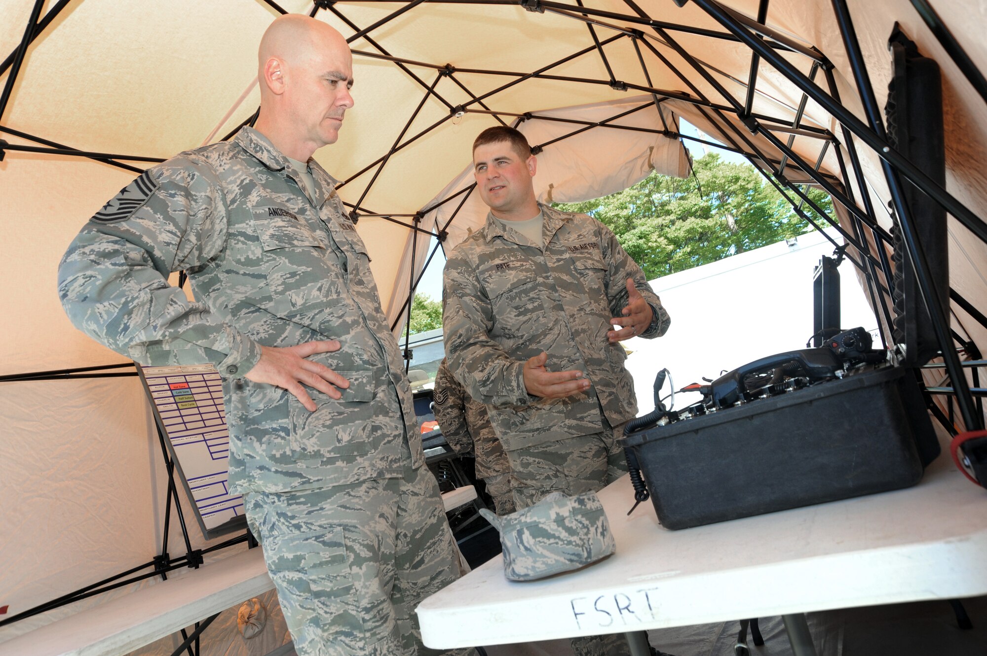 Tech Sgt. Dustin Pate, right, assigned to the 142nd Forces Support Squadron, describes some of the communication equipment used by the Fatality Search and Recovery Team (FSRT) to Ronald C. Anderson Jr., Command Chief Master Sgt., 1st Air Force, left, during his visit to the Portland Air National Guard Base, Ore., June 10, 2014. (Air National Guard photo by Tech. Sgt. John Hughel, 142nd Fighter Wing Public Affairs/Released)