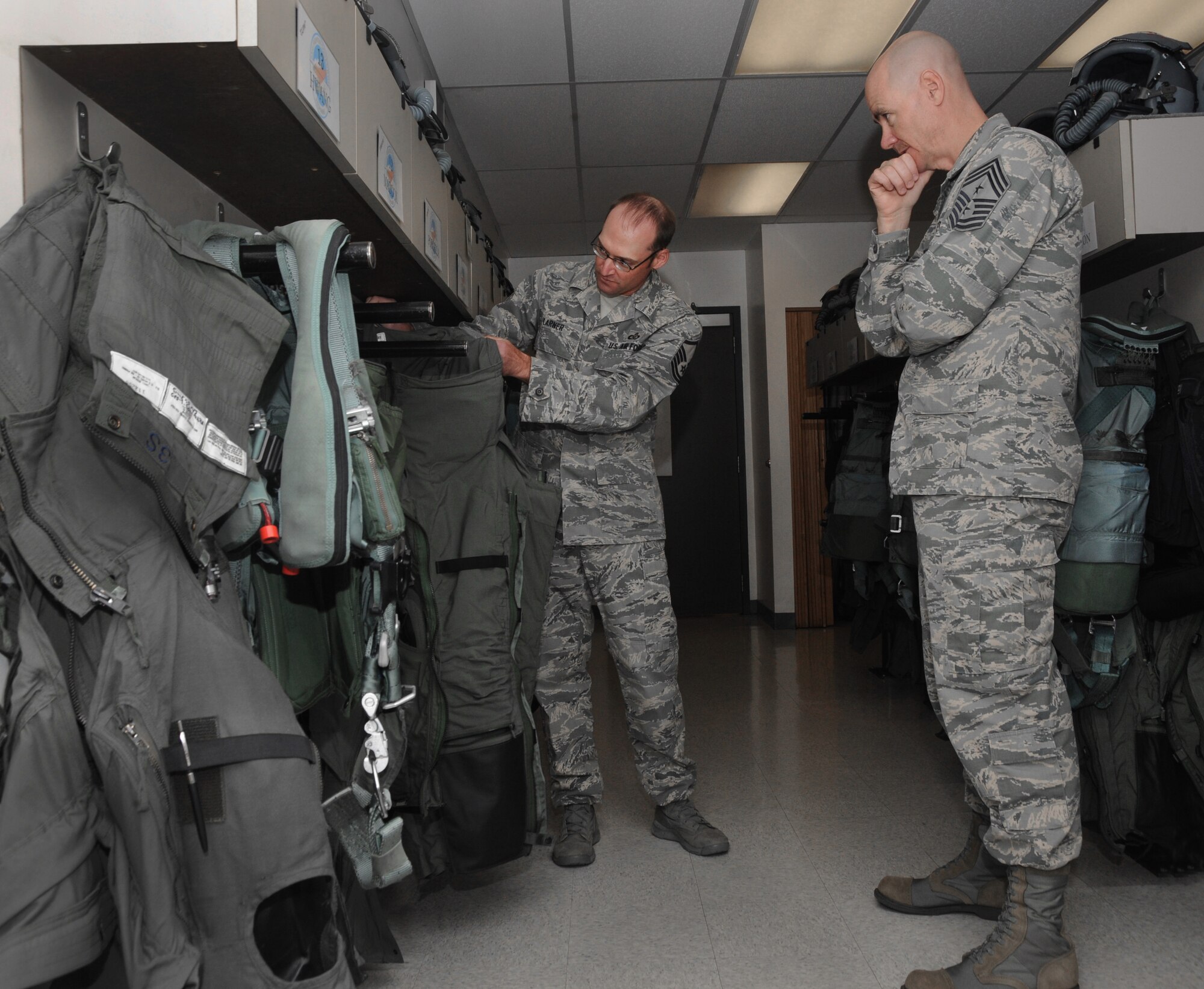 Ronald C. Anderson Jr., Command Chief Master Sgt., 1st Air Force, right, inspects new G-Suits with Master Sgt. Mike Larner, a flight equipment specialist, left, during his tour of the Portland Air National Guard Base, Ore., June 10, 2014. (Air National Guard photo by Tech. Sgt. John Hughel, 142nd Fighter Wing Public Affairs/Released)