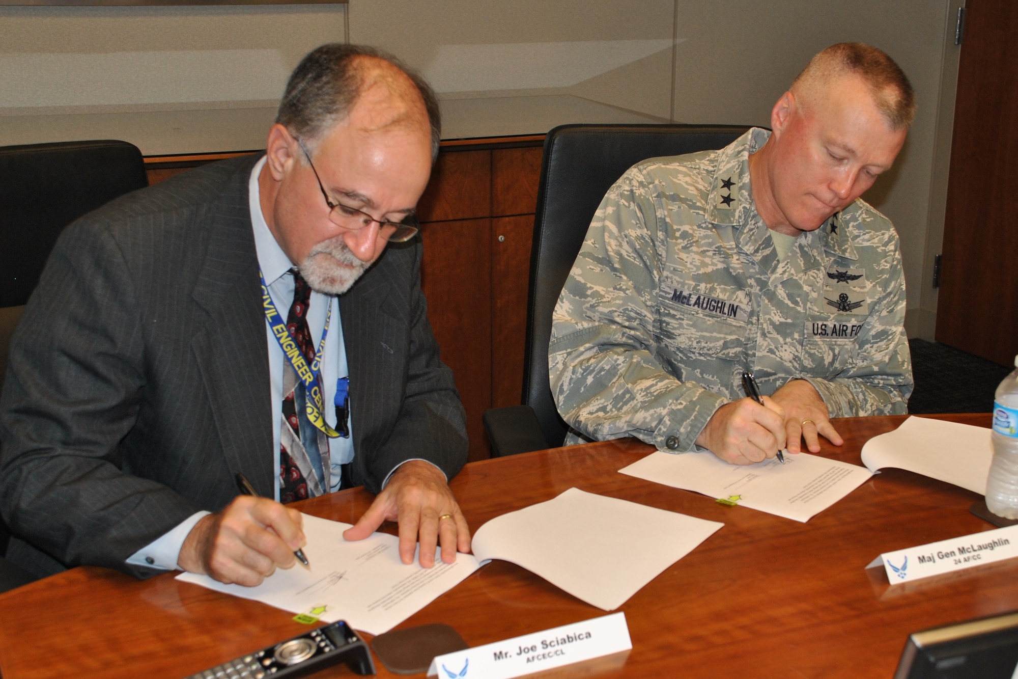 JOINT BASE SAN ANTONIO-LACKLAND, Texas -- Joe Sciabica, Air Force Civil Engineer Center director, and Maj. Gen. J. Kevin McLaughlin, 24th Air Force and Air Forces Cyber commander, sign the AFCEC-AFCYBER Nexus Collaboration during a meeting here June 12, 2014. The initiative is designed to increase collaboration between the agencies in order to enhance the security of industrial control systems supporting critical Air Force infrastructures around the world. (U.S. Air Force photo/Shannon Carabajal/Released)