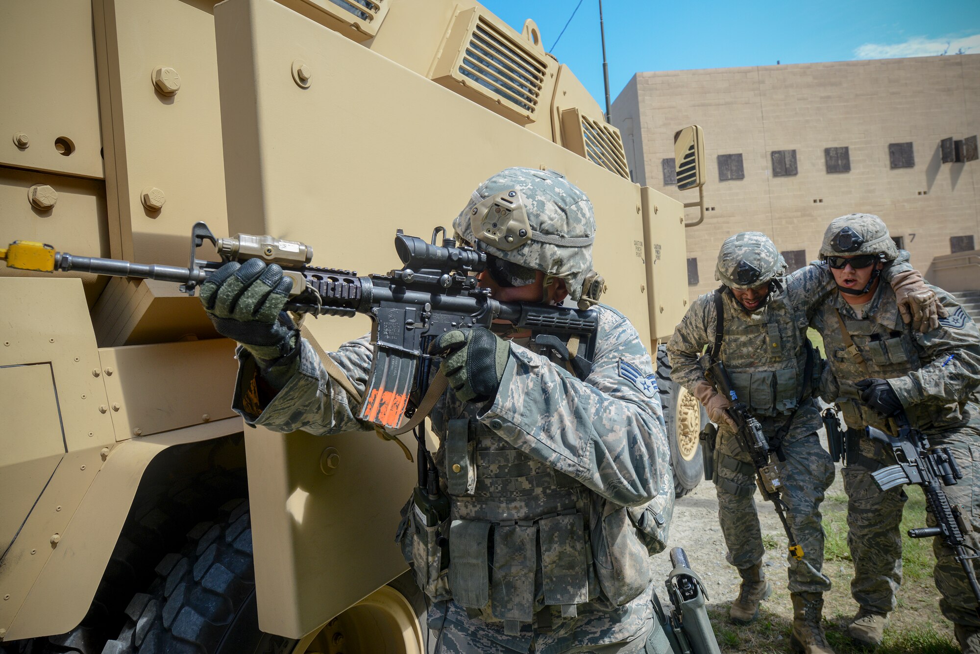 U.S. Air Force Senior Airman Nicholas Koch, 822nd Base Defense Squadron (BDS) fire team member, provides cover fire as wounded personnel are moved into a mine-resistant, ambush-protected vehicle as part of a training demonstration during the “Inside Combat Rescue: The Last Stand” media day at Moody Air Force Base, Ga., June 11, 2014. The demonstration showcased the capabilities of the 822nd BDS and allowed members of national media agencies to receive a personal look into their training environment. (U.S. Air Force photo by Senior Airman Douglas Ellis/Released)
