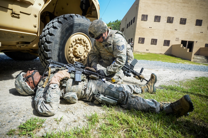 U.S. Air Force Staff Sgt. Eddie Morgan, 822nd Base Defense Squadron fire team leader, performs self-aid and buddy care on Senior Airman Shaun Jordan, 822nd BDS fire team member, at Moody Air Force Base, Ga., June 11, 2014. The 822nd BDS was featured in the National Geographic Channel’s new special, “Inside Combat Rescue: The Last Stand.”  The episode documents their recent deployment to Bagram Airfield, Afghanistan. (U.S. Air Force photo by Senior Airman Douglas Ellis/Released)

