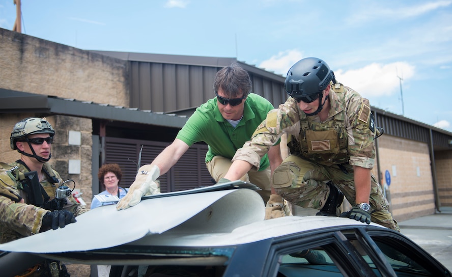 U.S. Air Force Staff Sgt. Alejandro Serrano, 38th Rescue Squadron pararescueman, and Lars Schwetje, Gannett Military Times multimedia journalist, tear the roof off of a sedan during a pararescue vehicular extraction demonstration at Moody Air Force Base, Ga., June 11, 2014. Members of the 38th RQS, alongside 822nd Base Defense Squadron Airmen, are showcased in this year’s National Geographic Channel special “Inside Combat Rescue: The Last Stand”. (U.S. Air Force photo by Airman Dillian Bamman/Released)