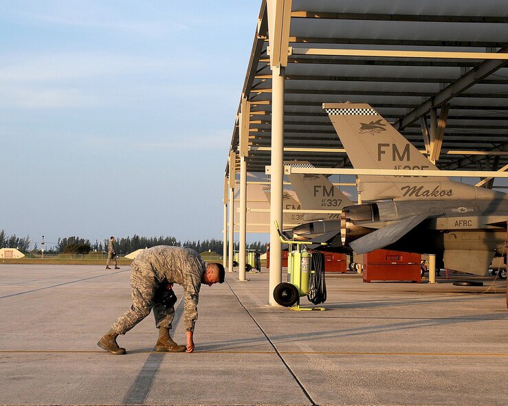 A member of the 482nd Maintenance Group, Homestead Air Reserve Base, Fla., participates in the daily foreign object damage walk on the “Mako” flightline on April 7.  Foreign object damage, known as FOD, is a virus that plagues the Air Force costing precious time and money to repair equipment inadvertently damaged. (U.S. Air Force photo/Senior Airman Jaimi Upthegrove)