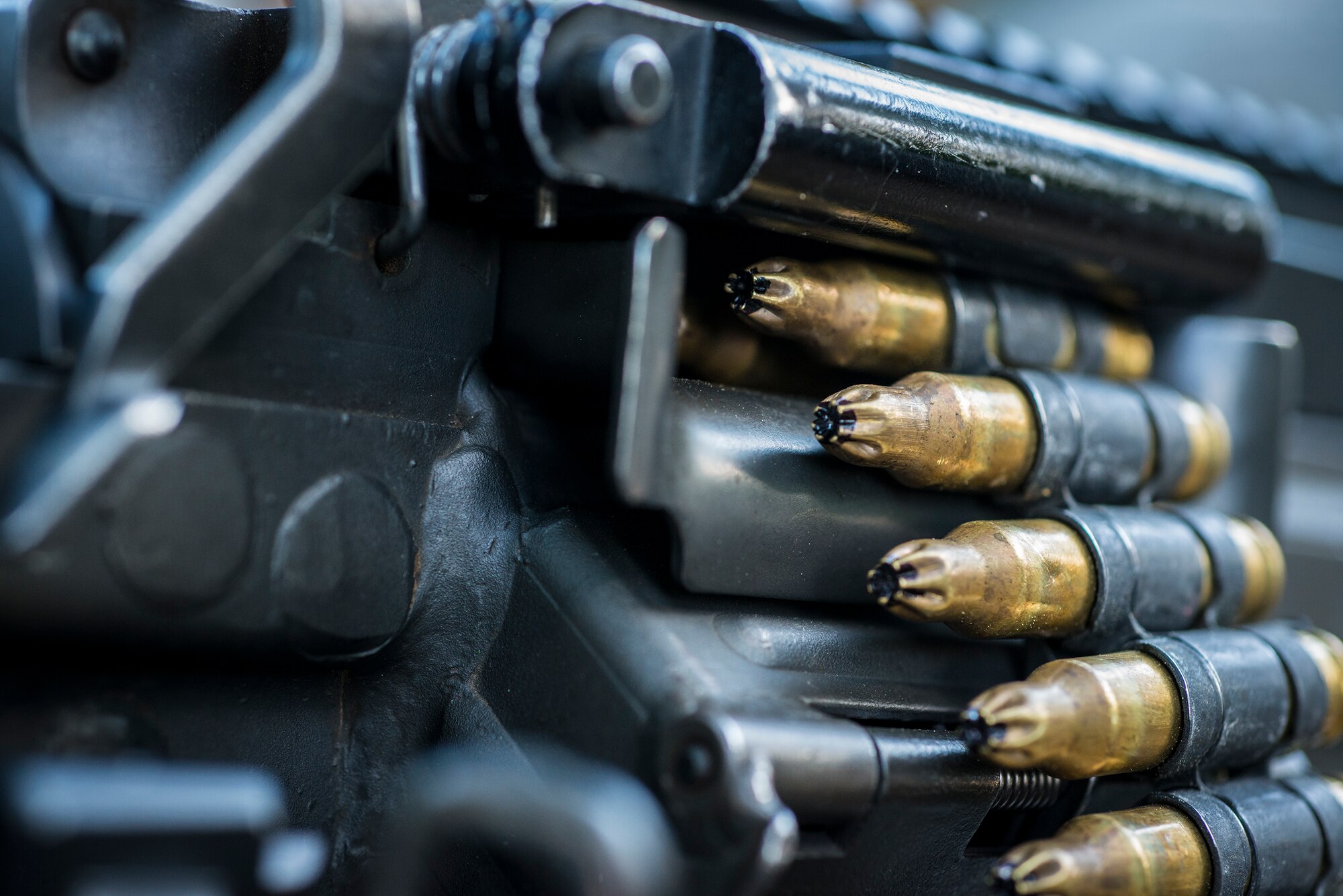 Blank ammunition hangs from an M249 light machine gun at Moody Air Force Base, Ga., June 11, 2014. Airmen from the 822nd Base Defense Squadron used blanks during an exercise at the military operations in urban terrain village to provide a realistic demonstration of their deployed operations as part of the “Inside Combat Rescue: The Last Stand” media day. (U.S. Air Force photo by Airman 1st Class Ryan Callaghan/Released)