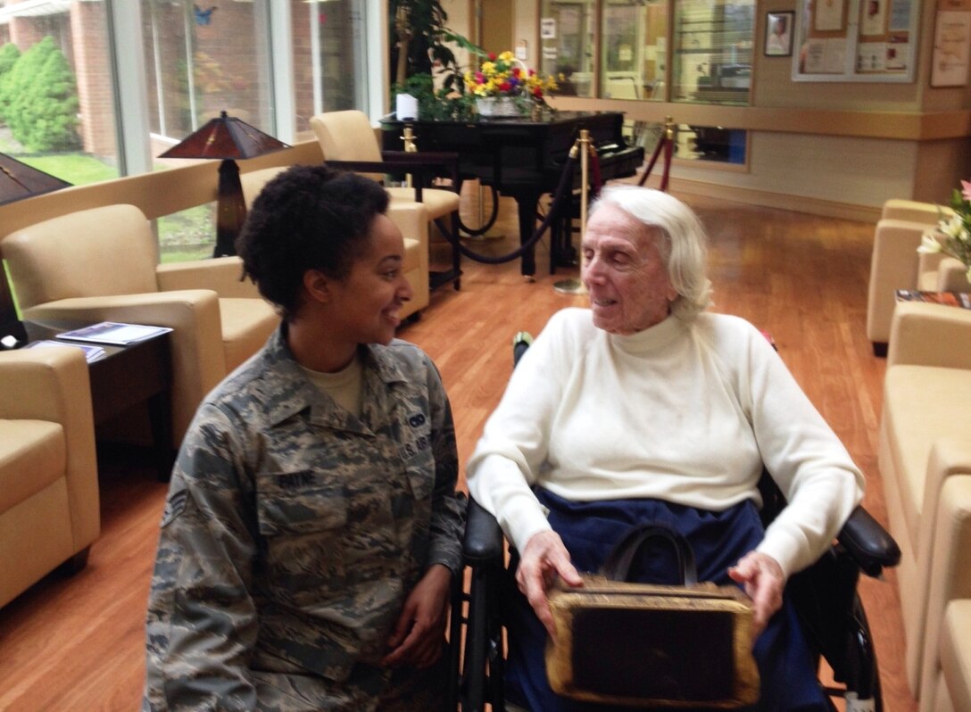 Senior Airman Emerald Payne, vocalist with the USAF Blue Aces, speaks with Mrs. Genevieve Landman Rausch, who served as part of the Women Air Force Service Pilots of World War II.  The Blue Aces performed for Mrs. Rausch and other veterans as part of the band’s tour visiting Veterans Administration facilities throughout the northeast.