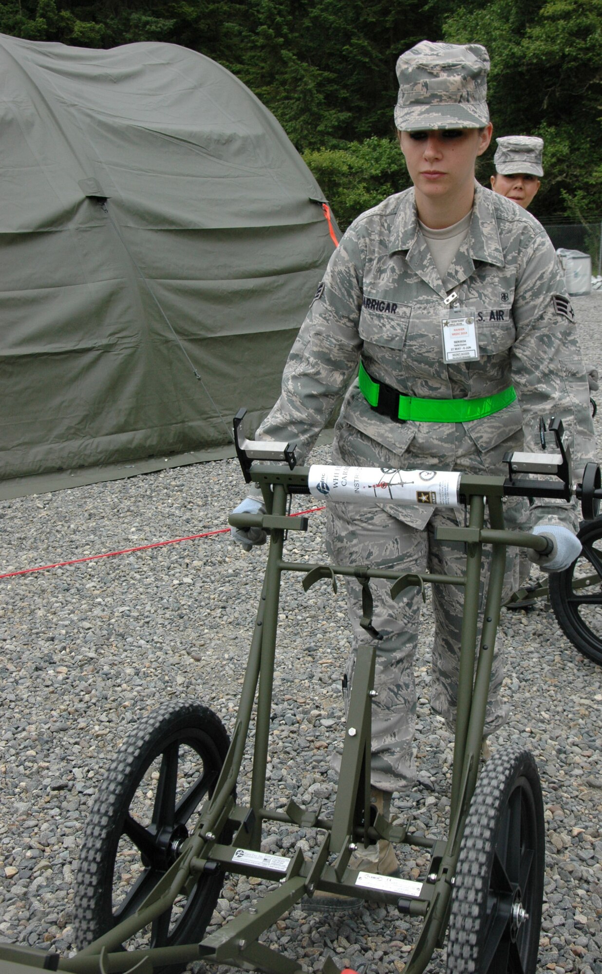 Senior Airman Elissa Barringar, 446th Aeromedical Staging Squadron, moves a NATO litter carrier into position to transport a patient awaiting movement on a C-17 during exercise Rainer Medic June 3 at Joint Base Lewis-McChord, Washington. (U.S. Air Force Reserve photo by Sandra Pishner)