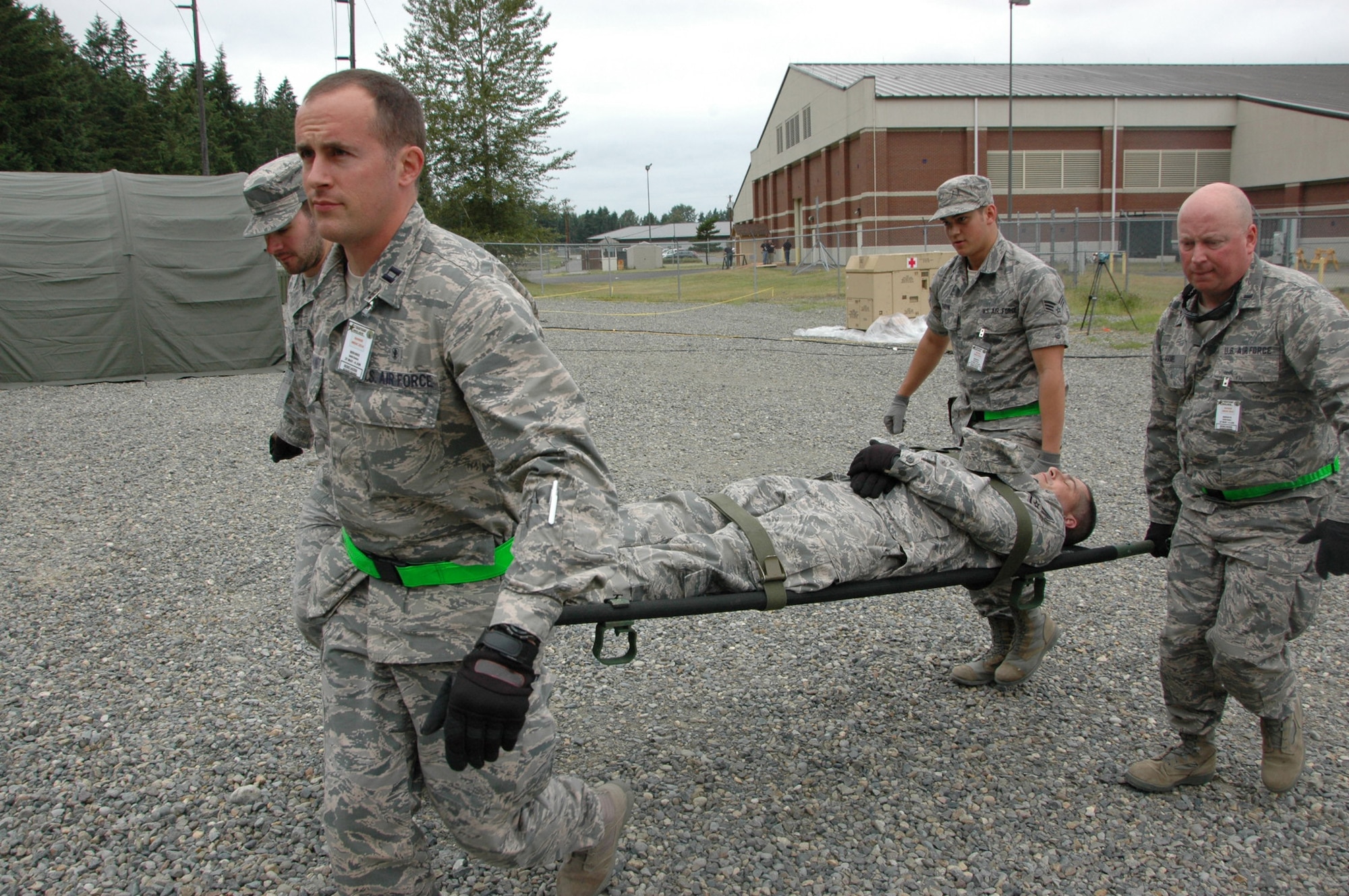 Airmen participating in the Rainier Medic course at Joint Base Lewis-McChord, Washington, carry an “injured” squadron member on a litter to a treatment area during exercise Rainier Medic June 3. Pictured front to back, left to right are Capt. Ryan Garabrandt, 446th Aeromedical Staging Squadron, Senior Airman Joshua Liko, 452nd ASTS, March Air Reserve Base, California, 1st Lt. Christopher Hamel,446th ASTS, and Senior Airman Jacob Garvin, 302nd ASTS, Peterson Air Force Base, Colorado. (U.S. Air Force Reserve photo by Sandra Pishner)