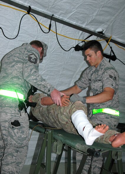 Master Sgt. Sean Colpitts, 446th Aeromedical Staging Squadron (left), and Senior Airman Jacob Garvin, 302nd ASTS, Peterson Air Force Base, Colorado, conduct an anti-hijacking exam of a patient prior to the patient being loaded on an aircraft for transportation. (U.S. Air Force Reserve photo by Sandra Pishner)