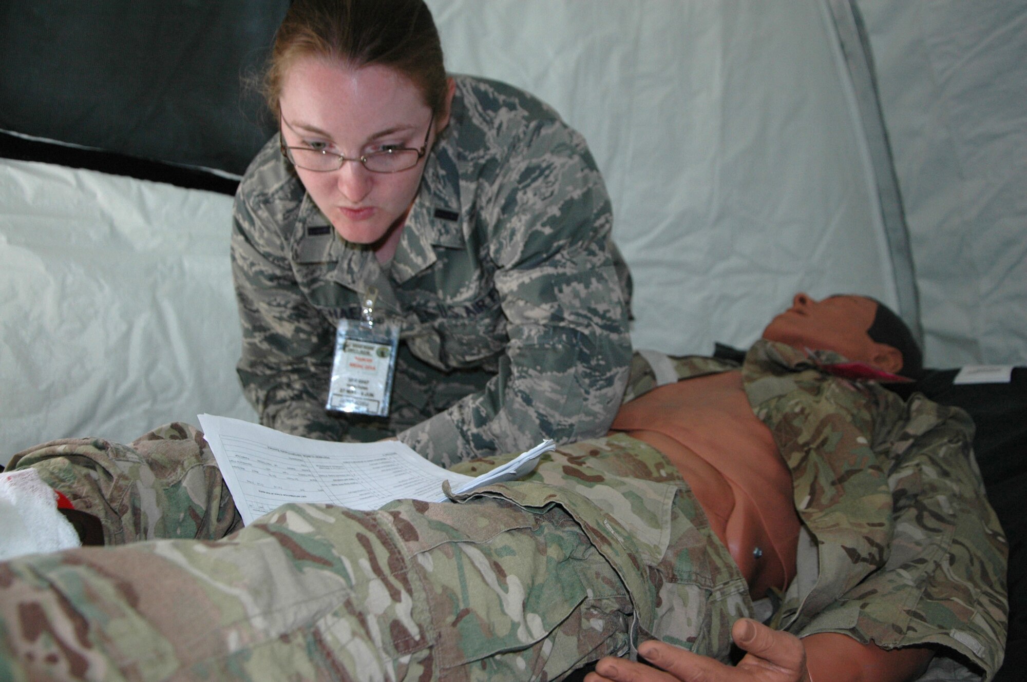 First Lt. Ariel Carmichael, 446th Aeromedical Staging Squadron, checks on a patient in her care at the En Route Patient Staging facility. (U.S. Air Force Reserve photo by Sandra Pishner)