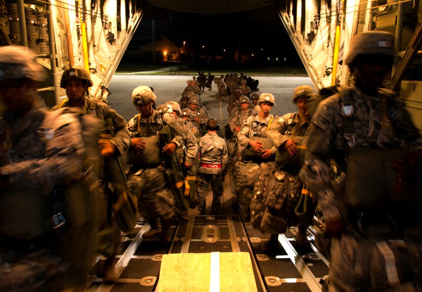 U.S. Army Soldiers assigned to the 82nd Airborne Division board a C-130J Super Hercules June 5, 2014, at Pope Army Airfield, Fort Bragg, N.C. Large artillery and more than 500 paratroopers were dropped by a six-ship formation onto Ft. Pickett during a night-time airdrop. (U.S. Air Force photo by Senior Airman Peter Thompson/Released)