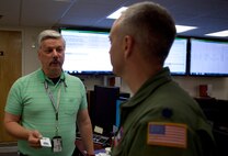 Robert Sigsbury helps Lt. Col. Barry Little, 90th Operations Support Squadron commander, in the 90th Communication Squadron's Communication Focal Point with a computer issue he is having. The monitors on the wall in the background track work orders and help CFP technicians manage their work flow. (U.S. Air Force photos by R.J. Oriez)