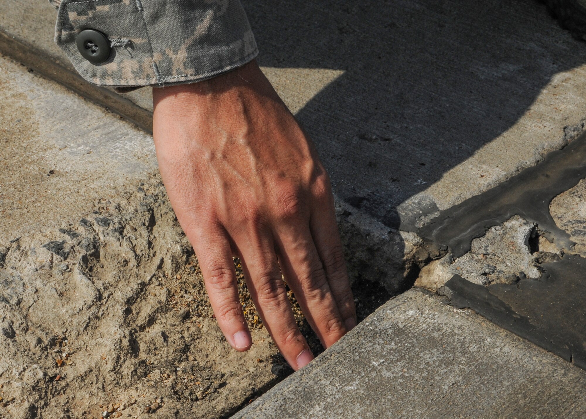 Senior Airman Jesus Gutierrez, 19th Operations Support Squadron Airfield management operations acting noncommissioned officer in charge, inspects worn pavement June 4, 2014, at Little Rock Air Force Base, Ark. Airfield operations Airmen work with the civil engineer squadron to ensure that any damage to the runway is repaired. (U.S. Air Force photo by Airman 1st Class Harry Brexel)