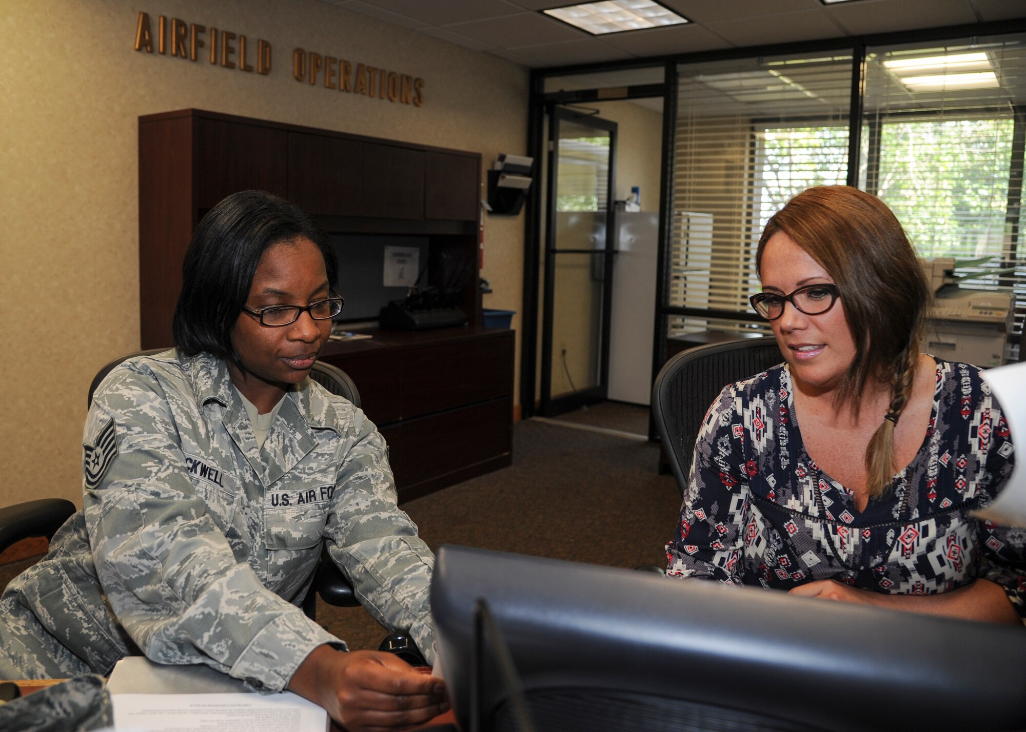 Tech. Sgt. Kimberly Blackwell, 19th Operations Support Squadron deputy airfield manager, and Tammy Hughes, 19th OSS airfield management secretary, review a flight plan June 4, 2014, at Little Rock Air Force Base, Ark. Managing flight plans is crucial to guarantee a safe and efficient airfield environment. (U.S. Air Force photo by Airman 1st Class Harry Brexel) 