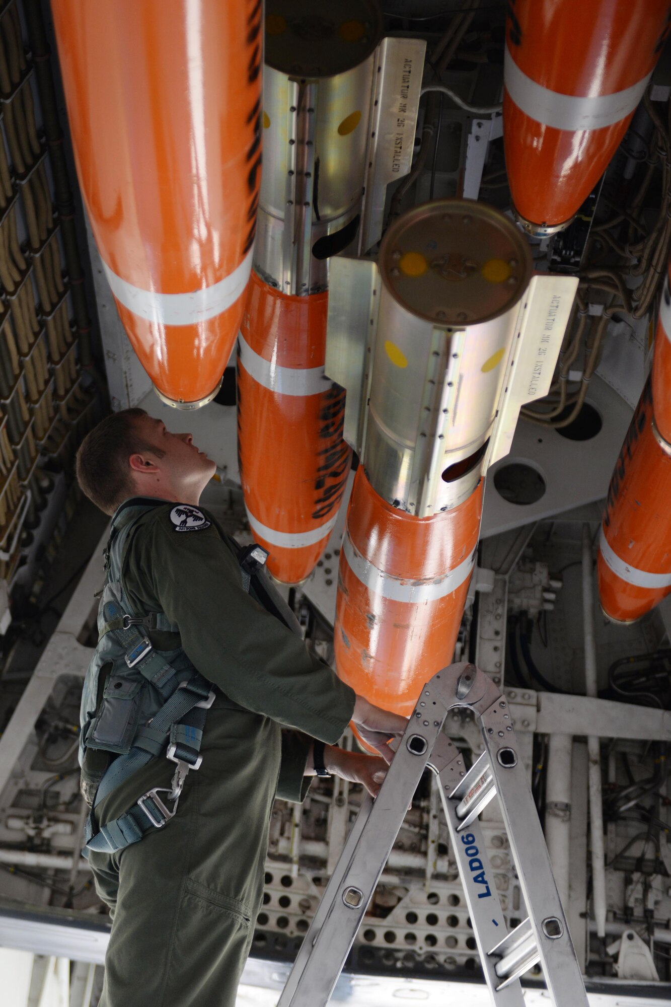 First Lt. Aaron Tindall, 34th Bomb Squadron B-1 weapons system officer, inspects munitions in the bomb bay of a B-1 bomber at Ellsworth Air Force Base, S.D., June 3, 2014. Base Airmen assisted Sailors in building, loading and deploying Mk-62 and Mk-65 Quick Strike mine munitions, strengthening joint operation mission capabilities and effectiveness. (U.S. Air Force photo by Airman 1st Class Rebecca Imwalle/Released)