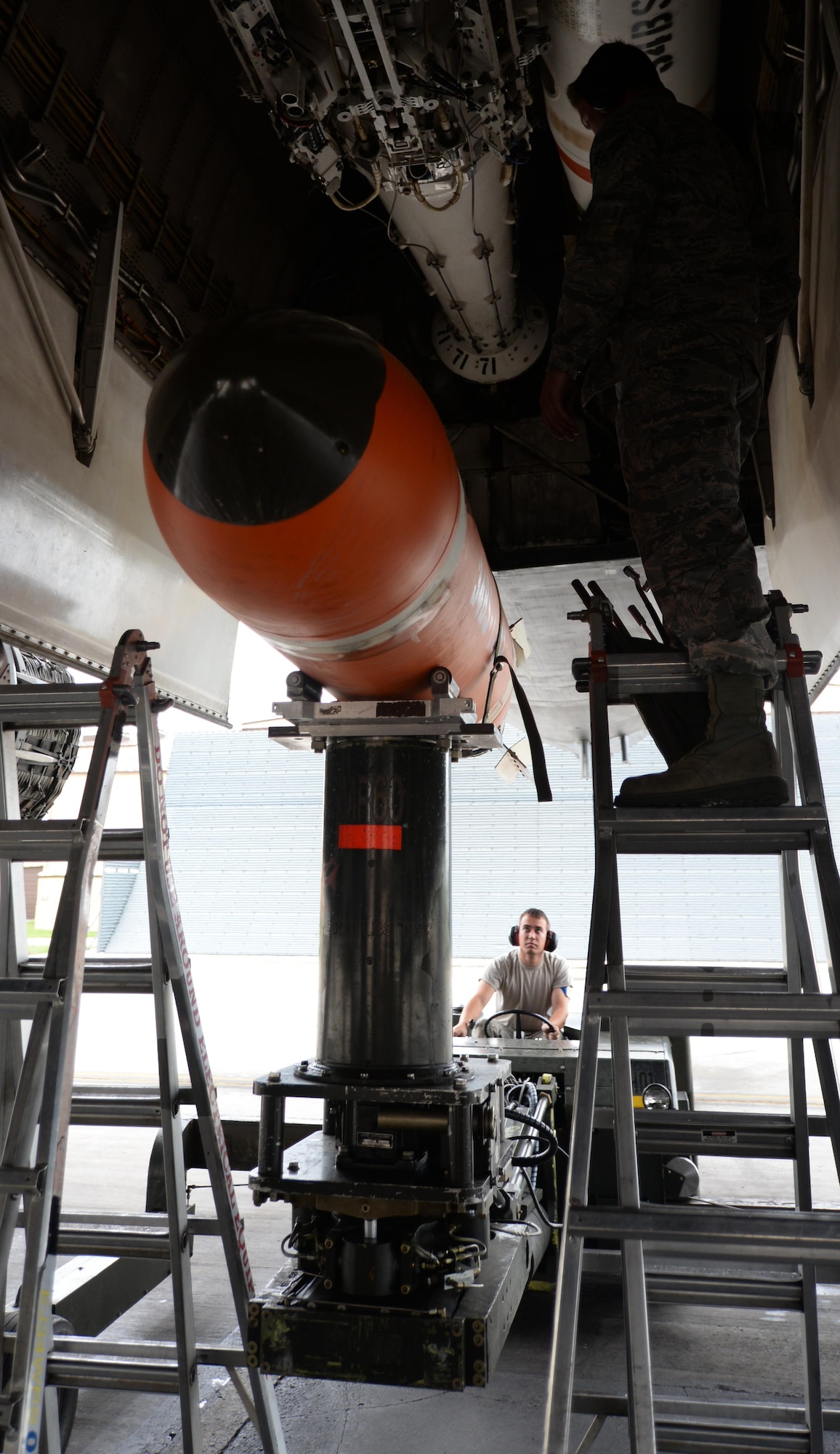 Airman 1st Class Trenton Anderson, 28th Munitions Squadron load crew member, loads an Mk-65 Quick Strike mine munitions into a B-1 bomber during a joint mission exercise at Ellsworth Air Force Base, S.D., June 3, 2014. Airmen and Sailors enhanced their skills by cooperatively assembling the different munition types. (U.S. Air Force photo by Airman 1st Class Rebecca Imwalle/Released)