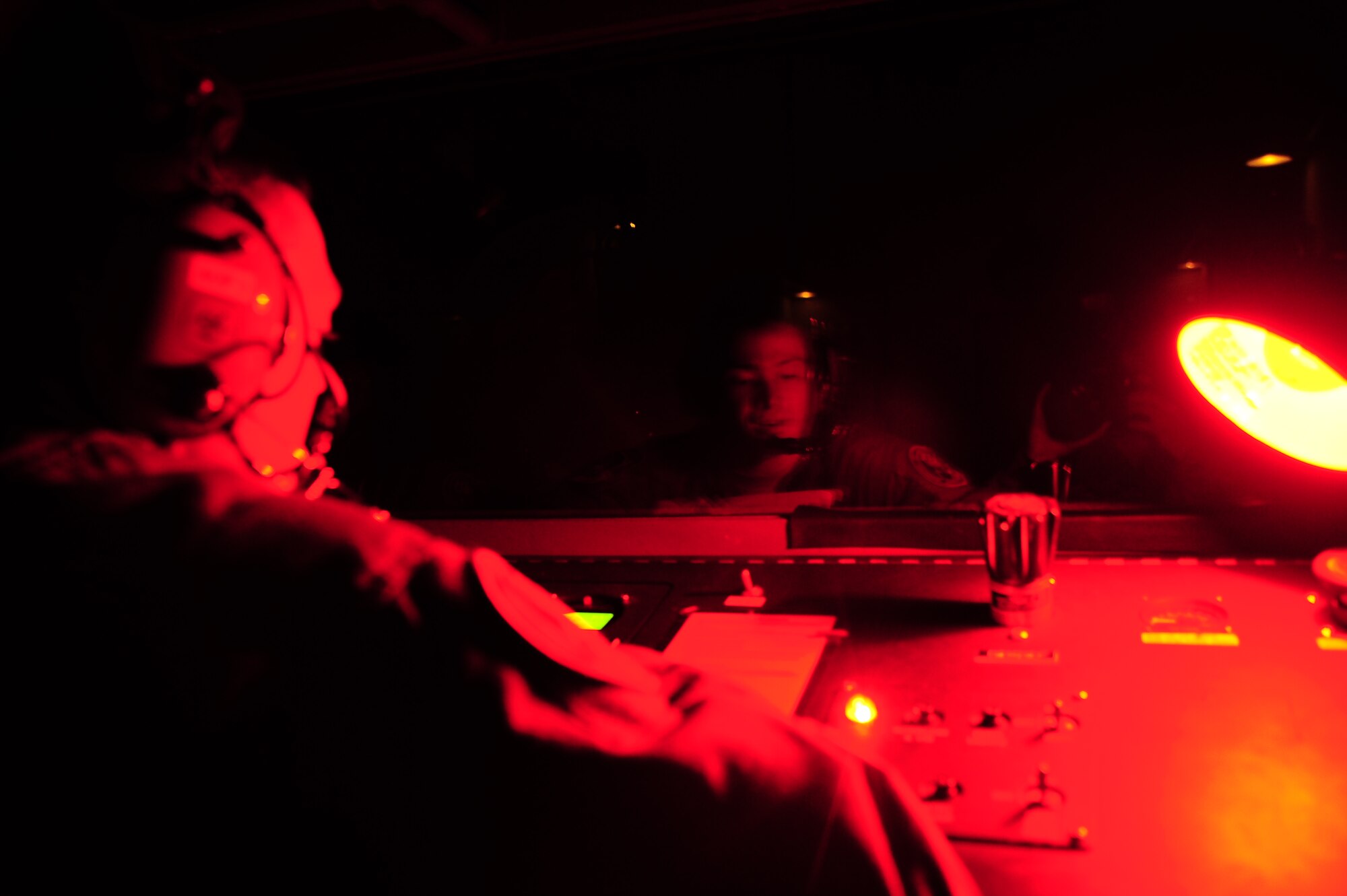 Senior Airman Kyle Nason looks into his reflection off a hypobaric chamber while giving aircraft personnel instructions on how to handle symptoms of hypoxia in the dark. As an AETC base with student pilots Columbus AFB having its own hyperbaric chamber is essential to giving training pilots and senior pilots the proper training they need to execute their job safely and efficiently. 