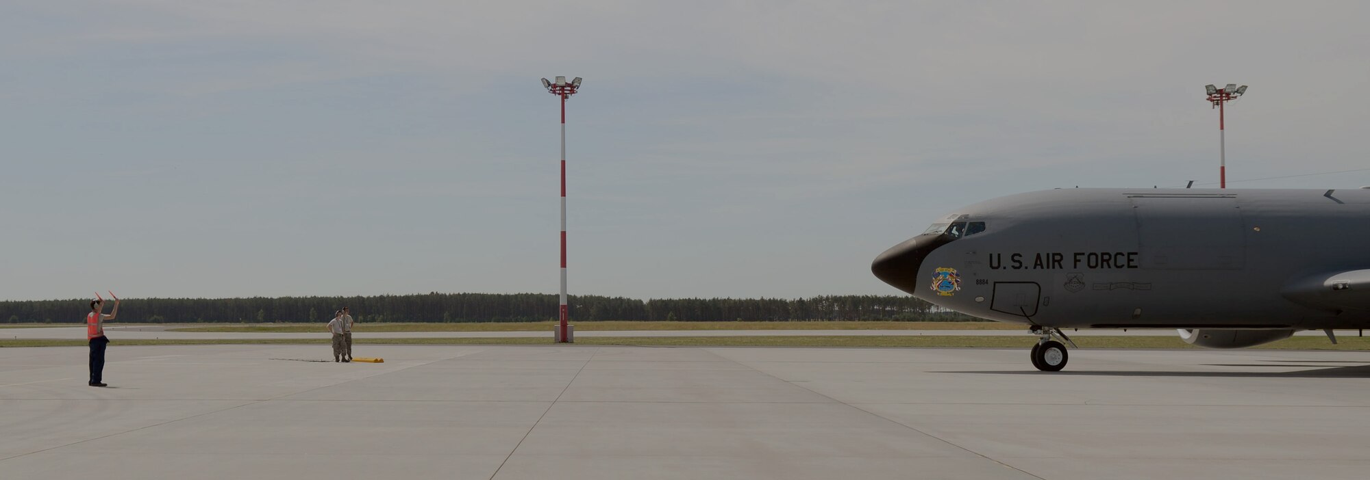 U.S. Air Force Senior Airman Alex Fletcher, left,  351st Expeditionary Air Refueling Squadron-Poland aerospace propulsion journeyman from Bradenton, Fla., guides a KC-135 Stratotanker as it taxis in from landing June 11, 2014, following a Baltic Operations Exercise mission out of Powidz Air Base, Poland. The BALTOPS Exercise demonstrates the U.S. Air Force’s commitment to its NATO allies and partners to promote peace and stability in the region. (U.S. Air Force photo/Airman 1st Class Kyla Gifford/Released)