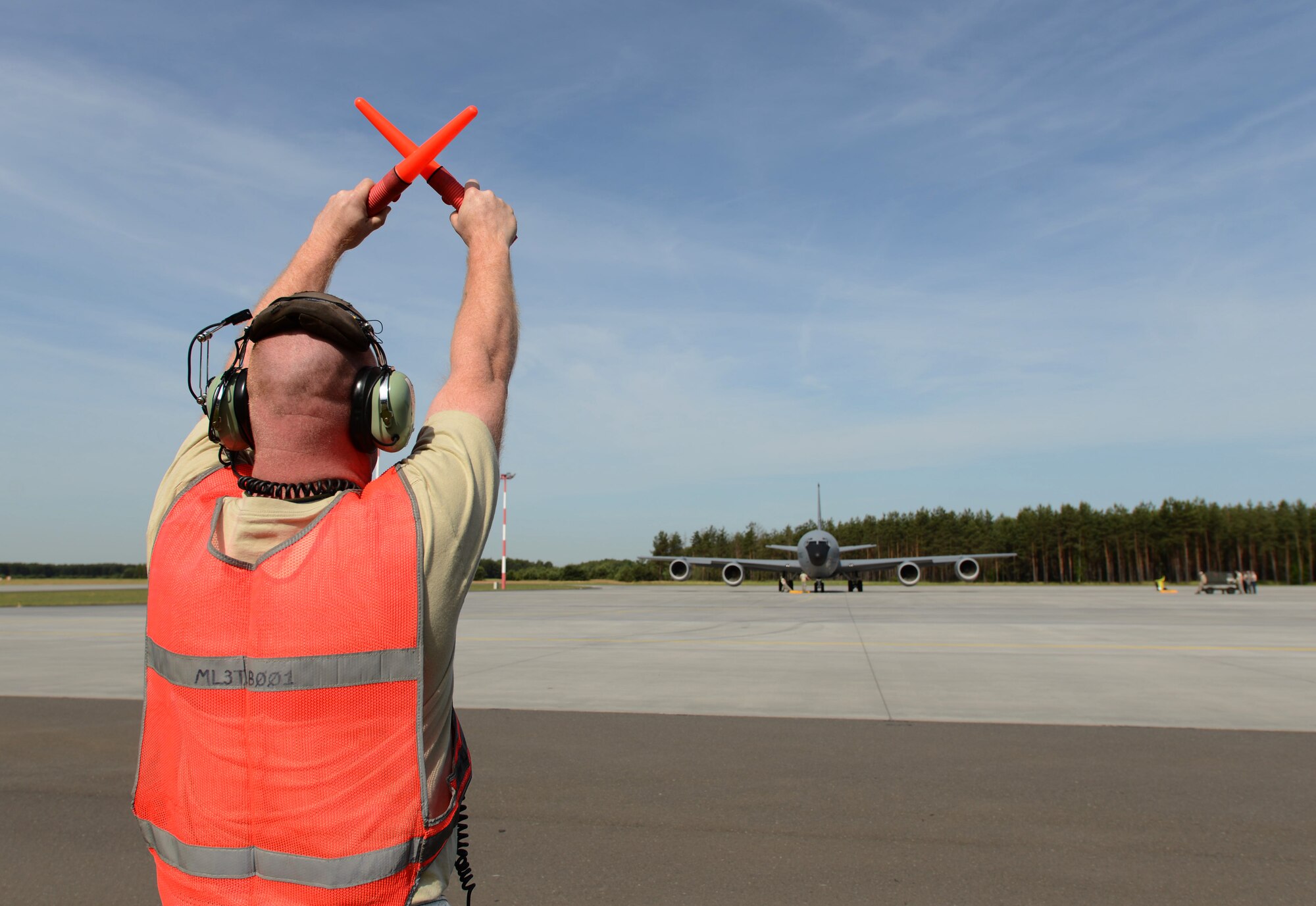 U.S. Air Force Tech. Sgt. Michael Mackey, 351st Expeditionary Air Refueling Squadron-Poland instrument and flight control systems craftsman from Indianapolis, guides a KC-135 Stratotanker as it taxis toward the runway June 11, 2014, for a Baltic Operations Exercise mission out of Powidz Air Base, Poland. The BALTOPS Exercise provides the opportunity for personnel of participating nations to engage in realistic training to build experience, teamwork and strengthen interoperability while working toward mutual goals. (U.S. Air Force photo/Airman 1st Class Kyla Gifford/Released)