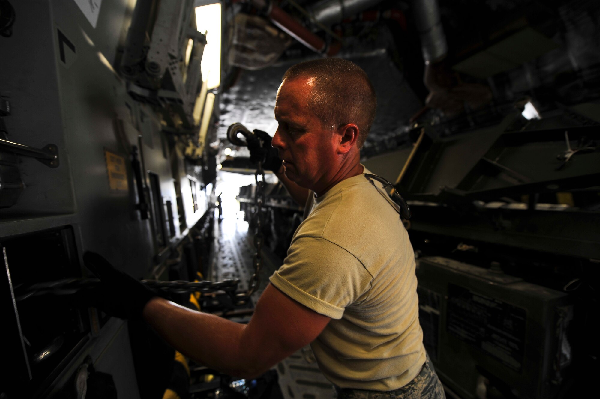 Tech. Sgt. Matthew Ingersoll, 380th Expeditionary Logistics Readiness Squadron, stows cargo strapping chains inside a C-17 June 11, 2014, at an undisclosed location in Southwest Asia. Air Terminal Operations Center Airmen are responsible for down-loading and up-loading cargo for all incoming and departing aircraft. (U.S. Air Force photo by Tech. Sgt. Russ Scalf/Released)